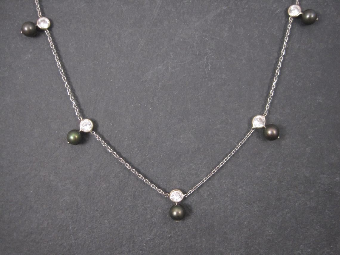 This beautiful necklace is 14k white gold.
It features 5 round 5mm peacock pearls and 5 round cut 4mm cubic zirconia stones.

Measurements: 17 inches from end to end

Marks: 14K, RCI

Condition: Excellent