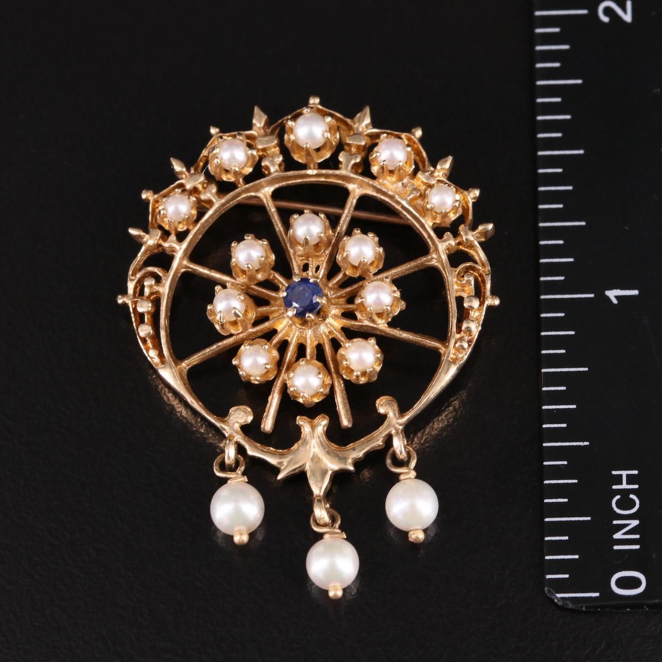 Embrace the classic elegance of this vintage 14K Cultured Pearl and Sapphire Brooch, a true testament to timeless sophistication. The brooch features a cluster of lustrous cultured pearls arranged in a graceful floral motif, each pearl exhibiting a