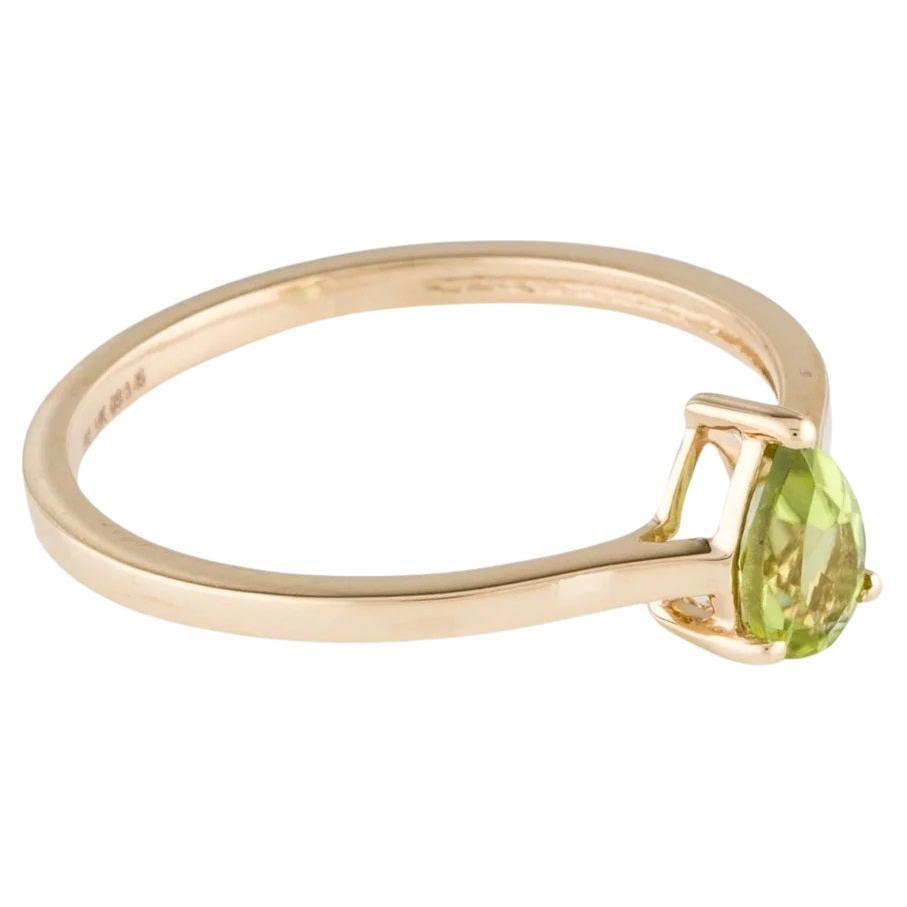 Elevate your style with this exquisite 14K Yellow Gold Peridot Cocktail Ring. Adorned with a vibrant 0.41 Carat Pear Modified Brilliant Peridot, this ring exudes elegance and sophistication. The pear-shaped gemstone is beautifully showcased within a