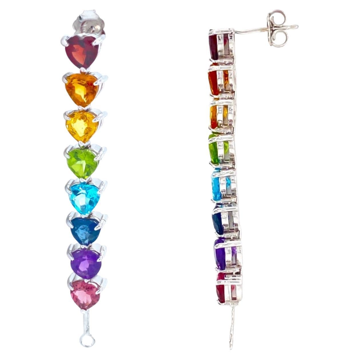 Drip in the full rainbow fantasy in the most unique and colorful drop earrings to light up your neck. These earrings are like no other and consists of heart settings with colored gems and sapphires in the Classic Mordekai rainbow pattern. Goes
