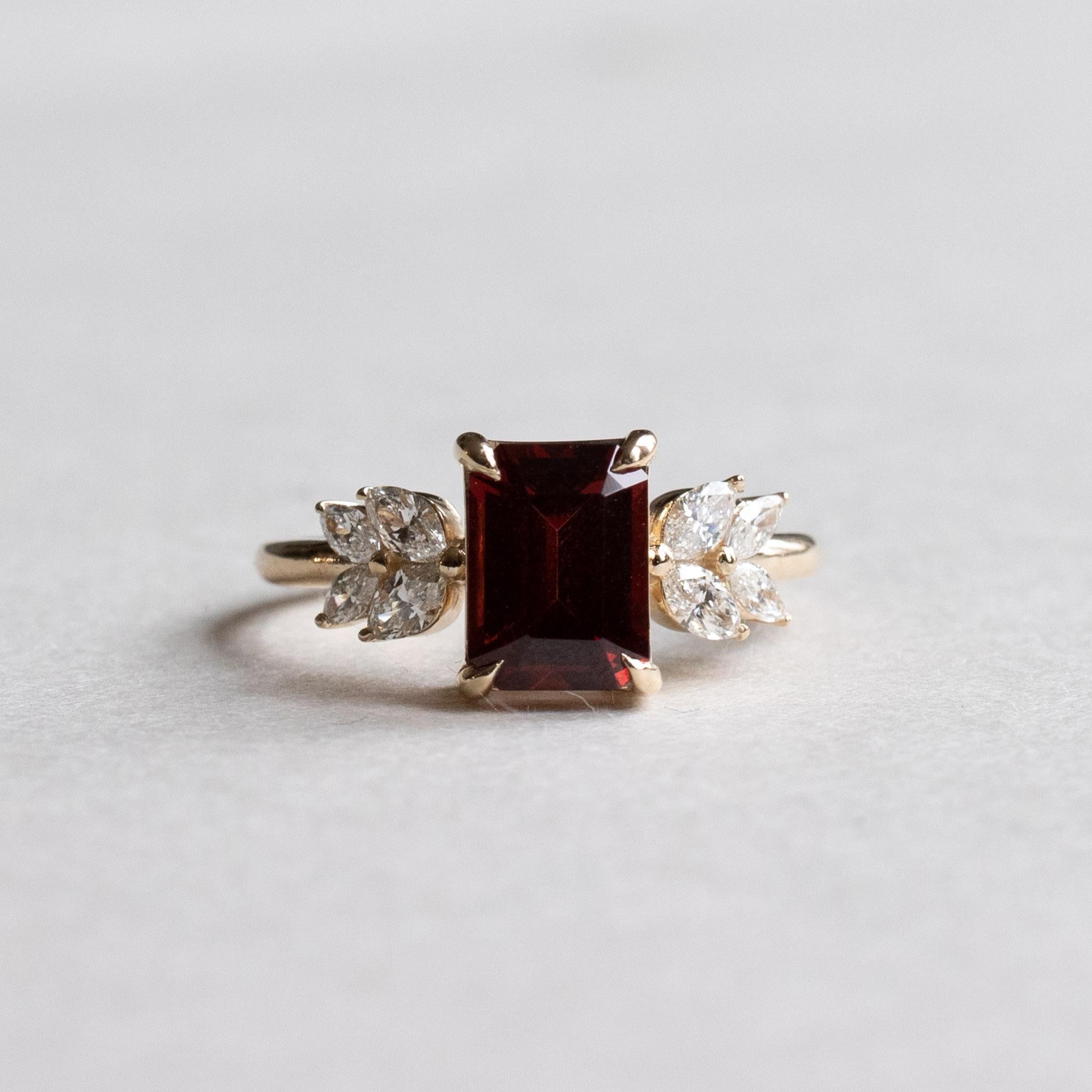 Metal: 14K Yellow Gold
Stone: Emerald Cut Garnet 
Stone Weight: 1.5 carat
Stone Size: 5.75mm x 7.79mm
Accent Stones: Natural Diamonds
Accent Shapes: Marquise 
Shank: 1.6mm