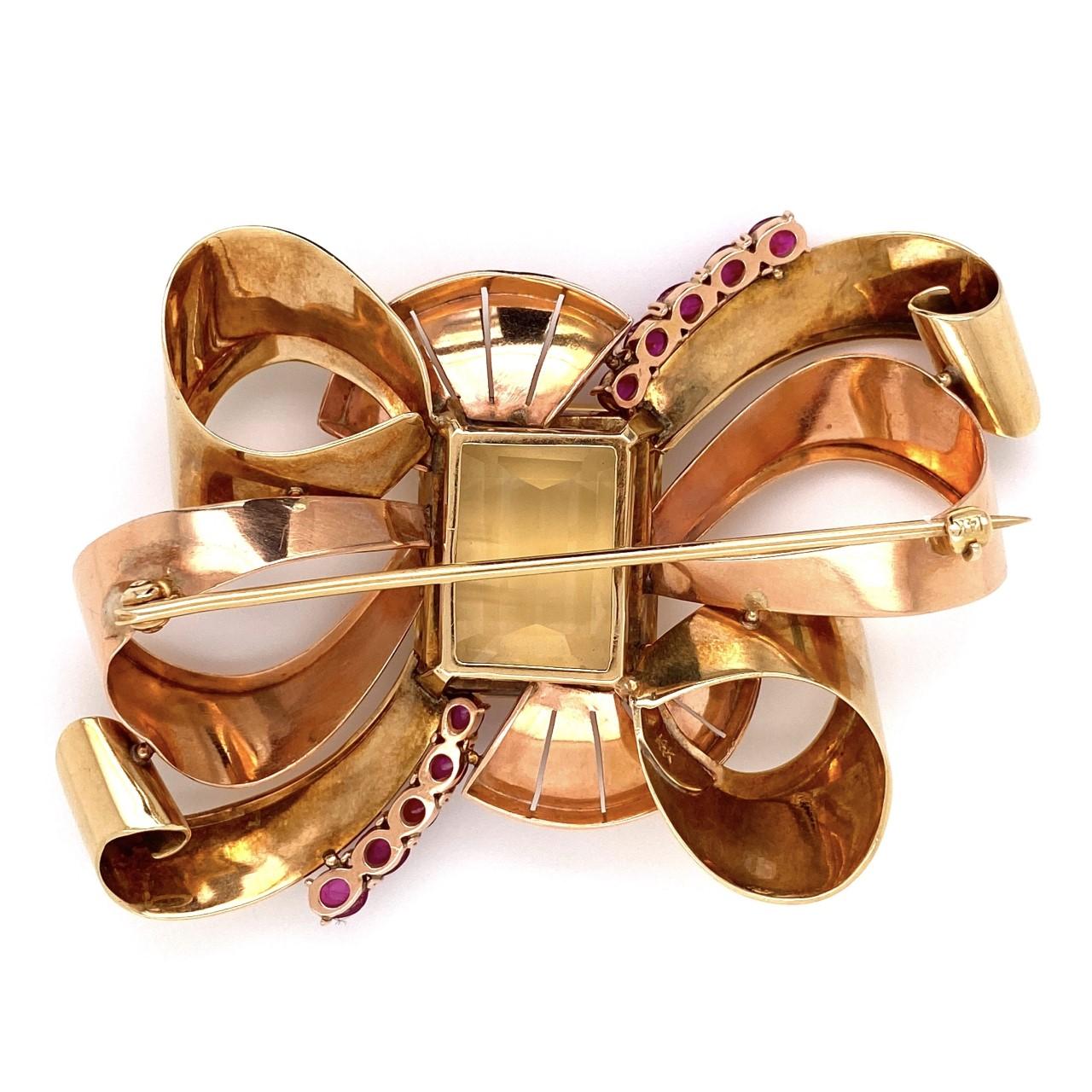 Description
This beautiful brooch is Retro from the 1940´s constructed of the fine 14k green & rose gold and has large emerald citrine quartz weighing approx. 49cts. There are 10 cabochon red rubies accent stones weighing approx. 1.00tcw.
•	Citrine