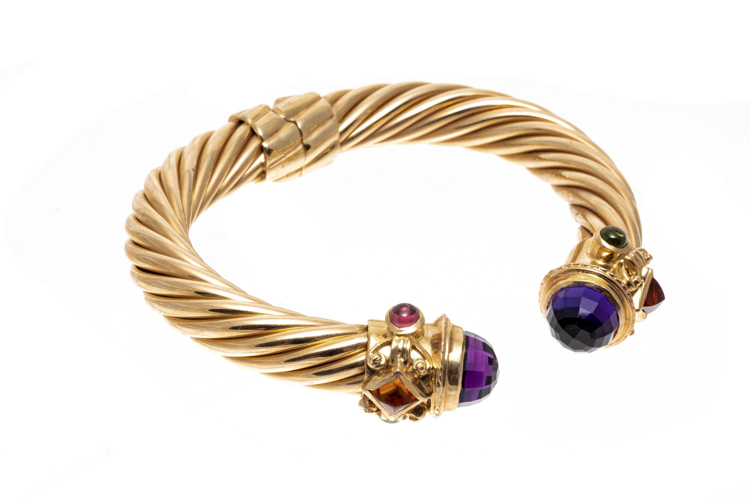 14k Yellow Gold Ribbed Open Cuff Bangle Bracelet Set With Amethyst, Tourmaline And Citrine.
This imposing bracelet is a hinged, ribbed, open cuff style bangle, with baroque style ends set with square cabachon cut yellow citrines, round cabachon pink