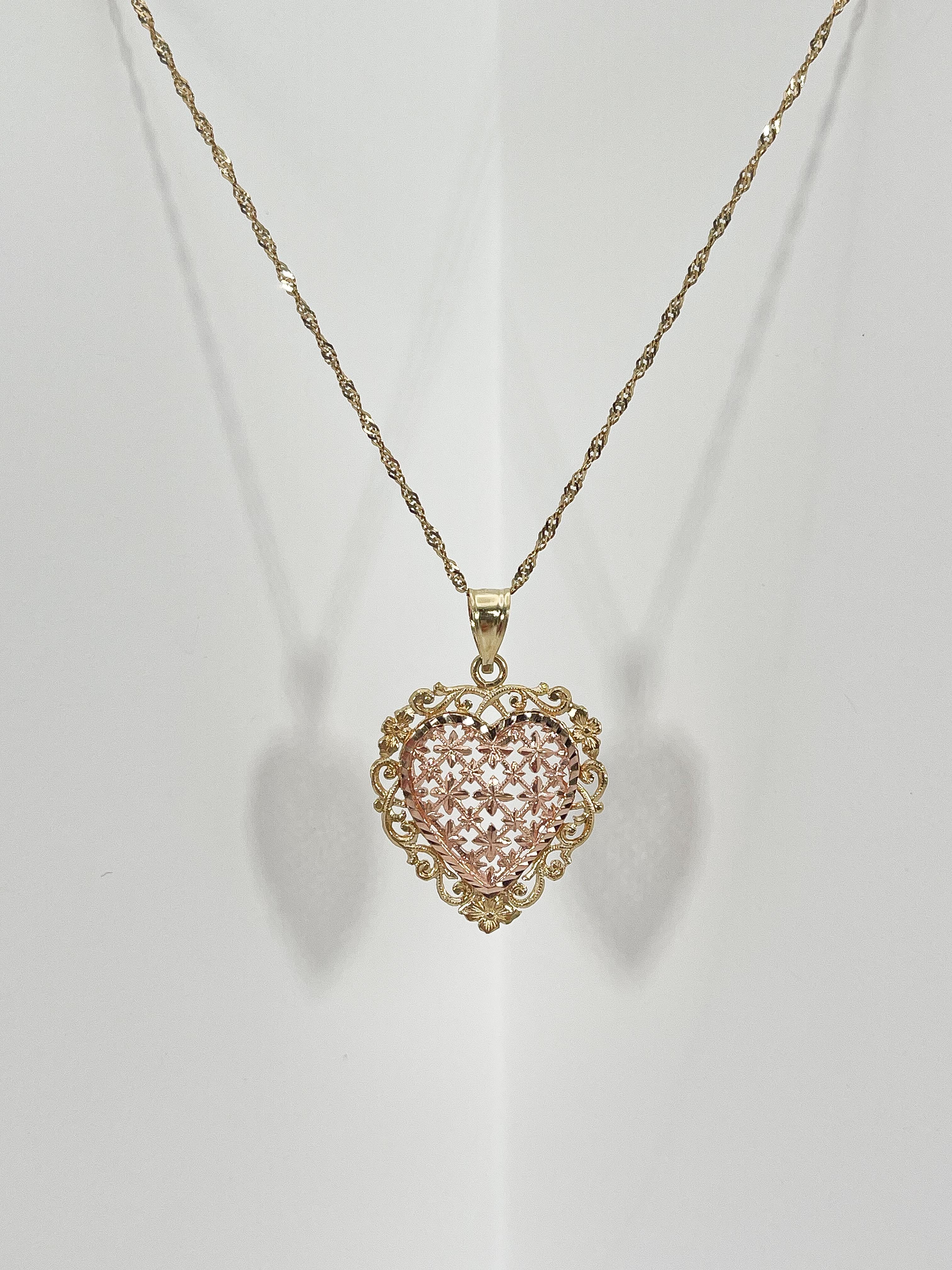 14k rose and yellow gold filigree heart pendant necklace. Pendant measures to be 20.5mm x 20.5mm, comes on an 18 inch diamond cut twist chain, has a spring ring to open and close necklace, and necklace has a total weight of 3.2 grams.