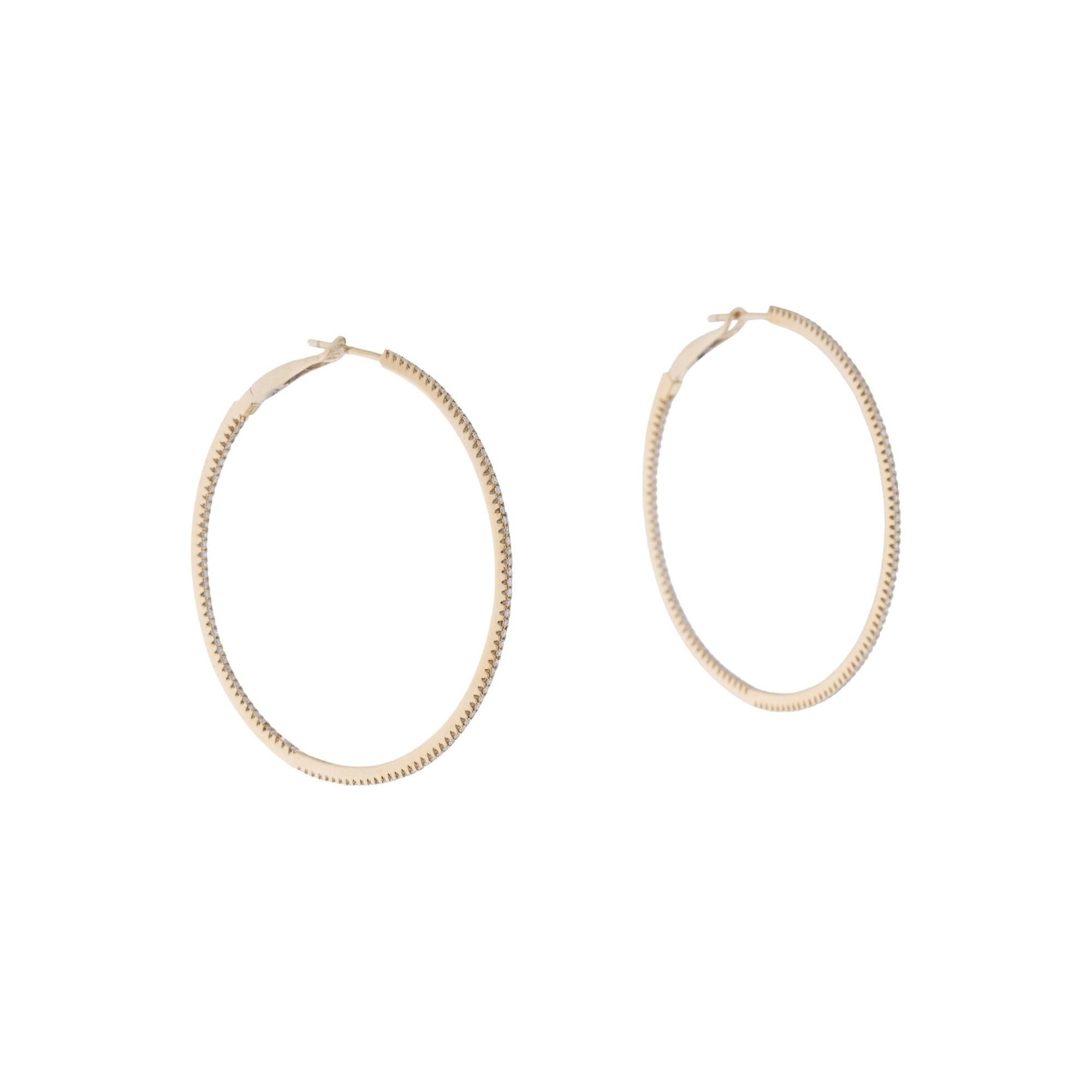 Light up your favorite looks with the brilliance of diamonds! Shimmering and bright, these gorgeous narrow round hoops glisten with approximately 0.59ct diamonds along the outer edge. Diamond color and clarity is GH SI1-SI2. Lever backs provide a