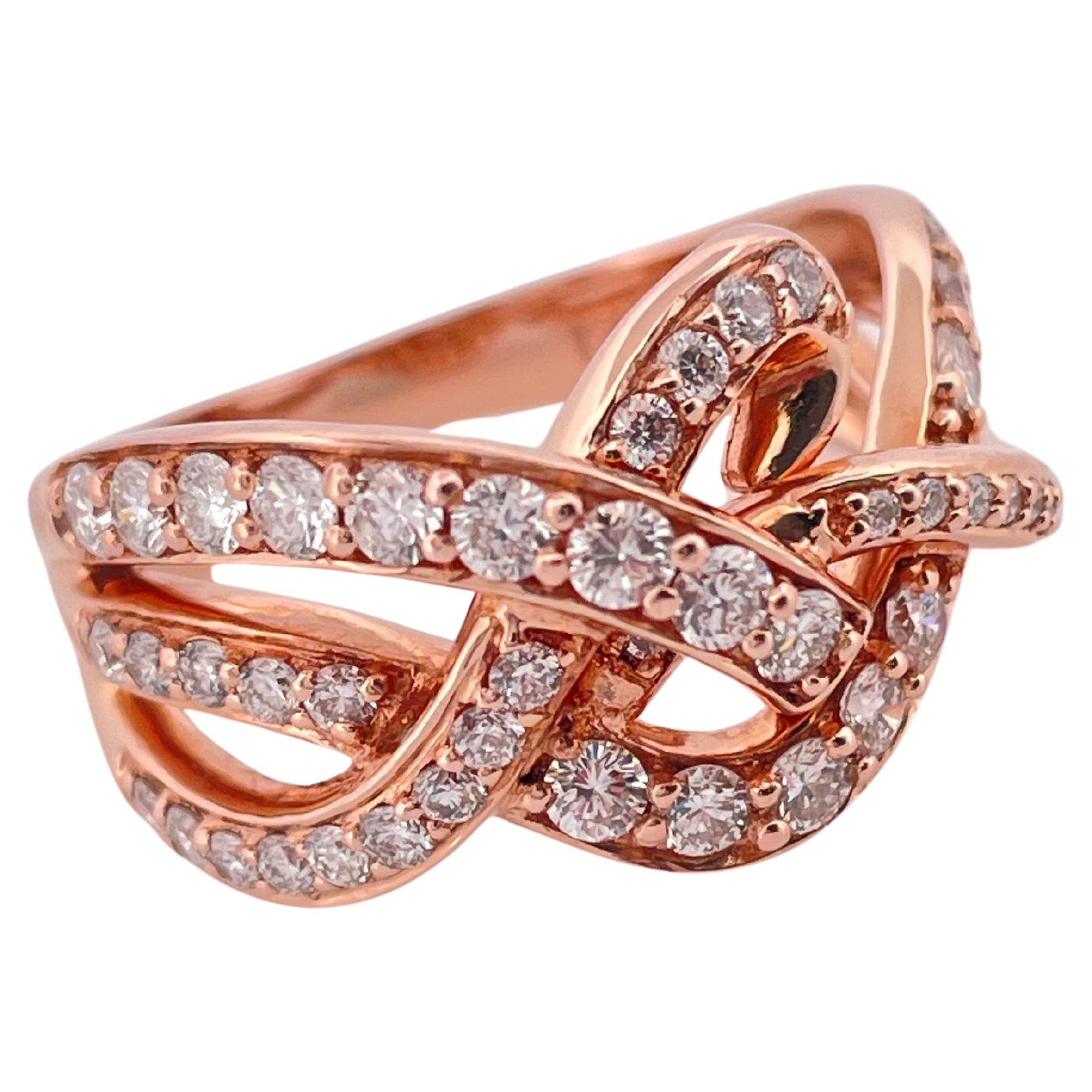 Este elegante anillo Le Vian, elaborado en oro rosa de 14 quilates, exhibe la característica mezcla de sofisticación y arte de la marca. Con un peso total aproximado de 0,85 quilates en diamantes, el diseño presenta un intrincado entrelazado de