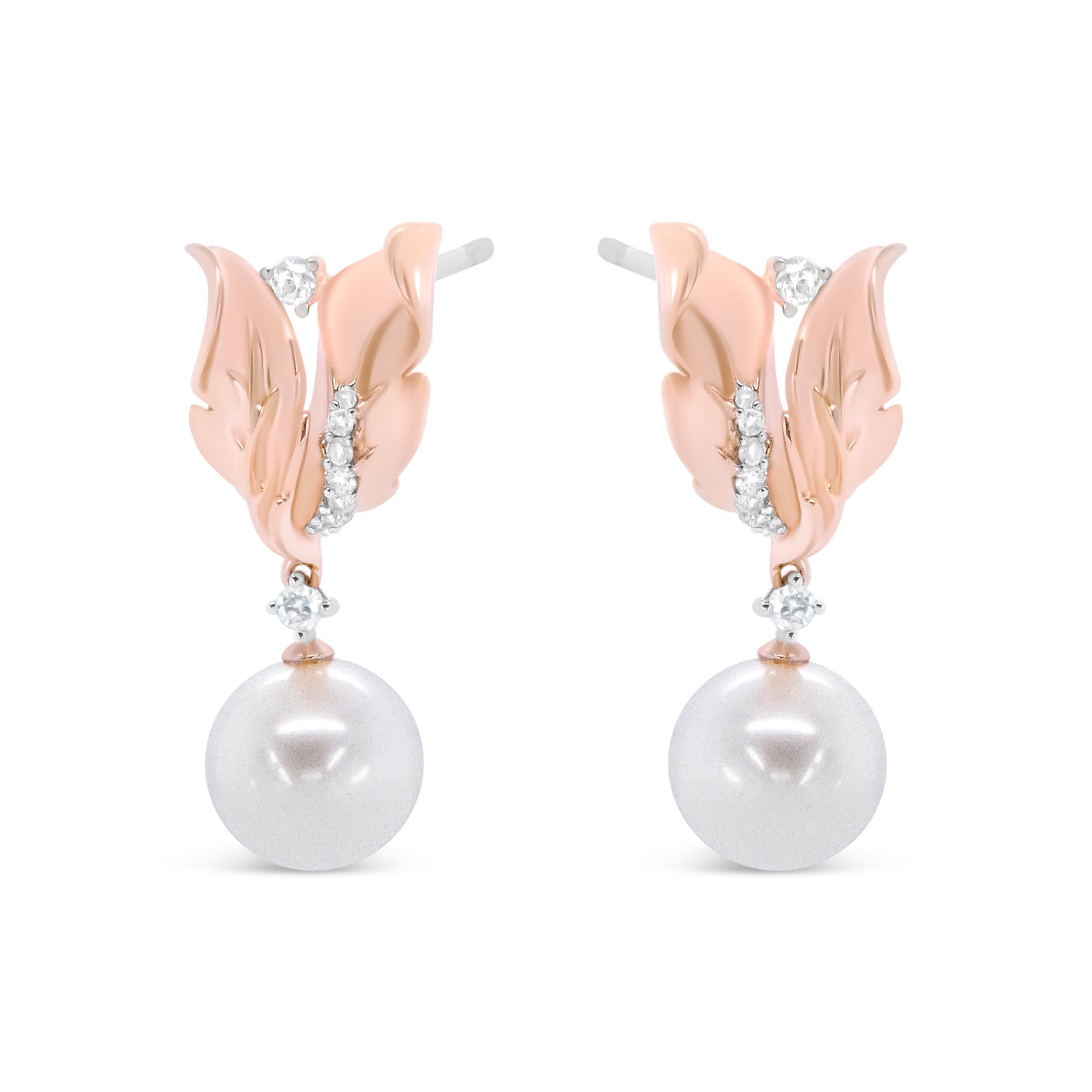 Enlivened by a 8mm round ivory pearl, these drop earrings make a remarkable statement of style on the ears. The graceful elegance of each pearl is accompanied by round white diamonds in prong and pave settings, each placed in an ornate floral leaf