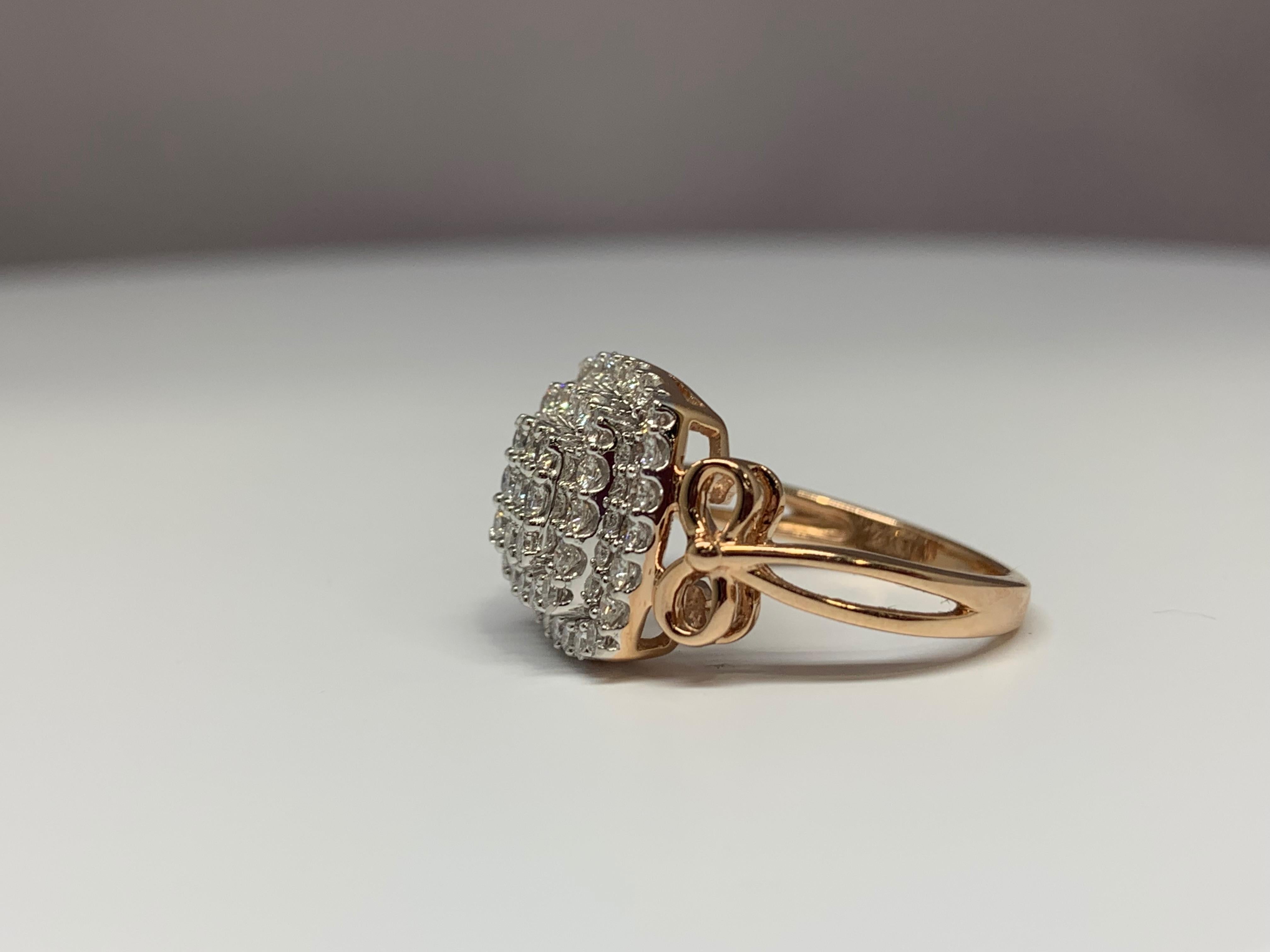This beautiful 14K rose gold diamond cluster cocktail ring holds a 1.00 carat total weight of round white diamonds. The ring features a double-halo design with prong-set diamonds and a split-shank detail. The ring is currently a size 7 but can be