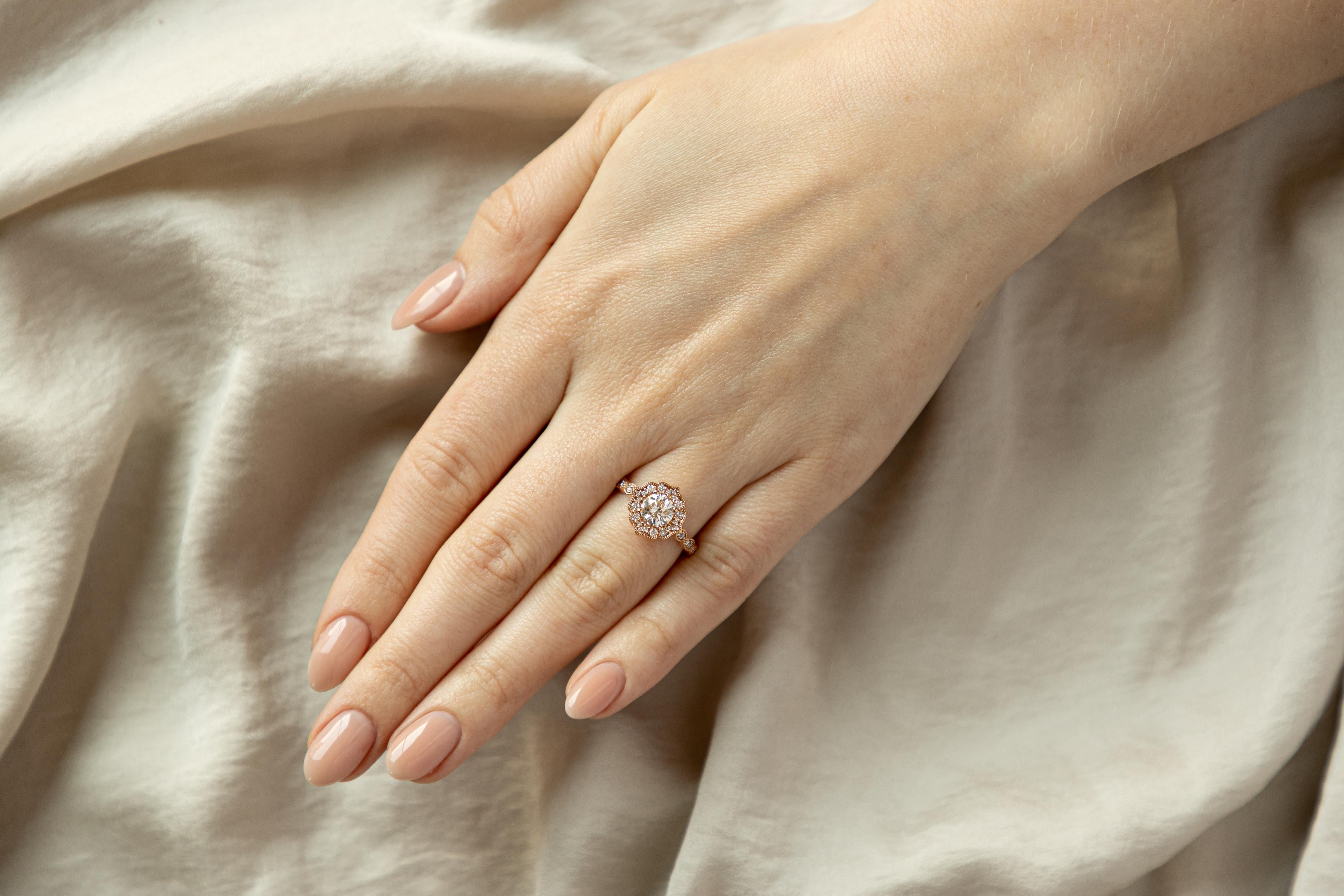 Era: New 

Composition: 14K Rose Gold

Primary Stone: Round Brilliant Cut Diamond

Carat Weight: 1.02 Carats

Color/ Clarity: H / SI1

GIA Report Number: 6411137538

Accent Stone: Thirty Two Round Brilliant Cut Diamonds

Carat Weight: Approximately