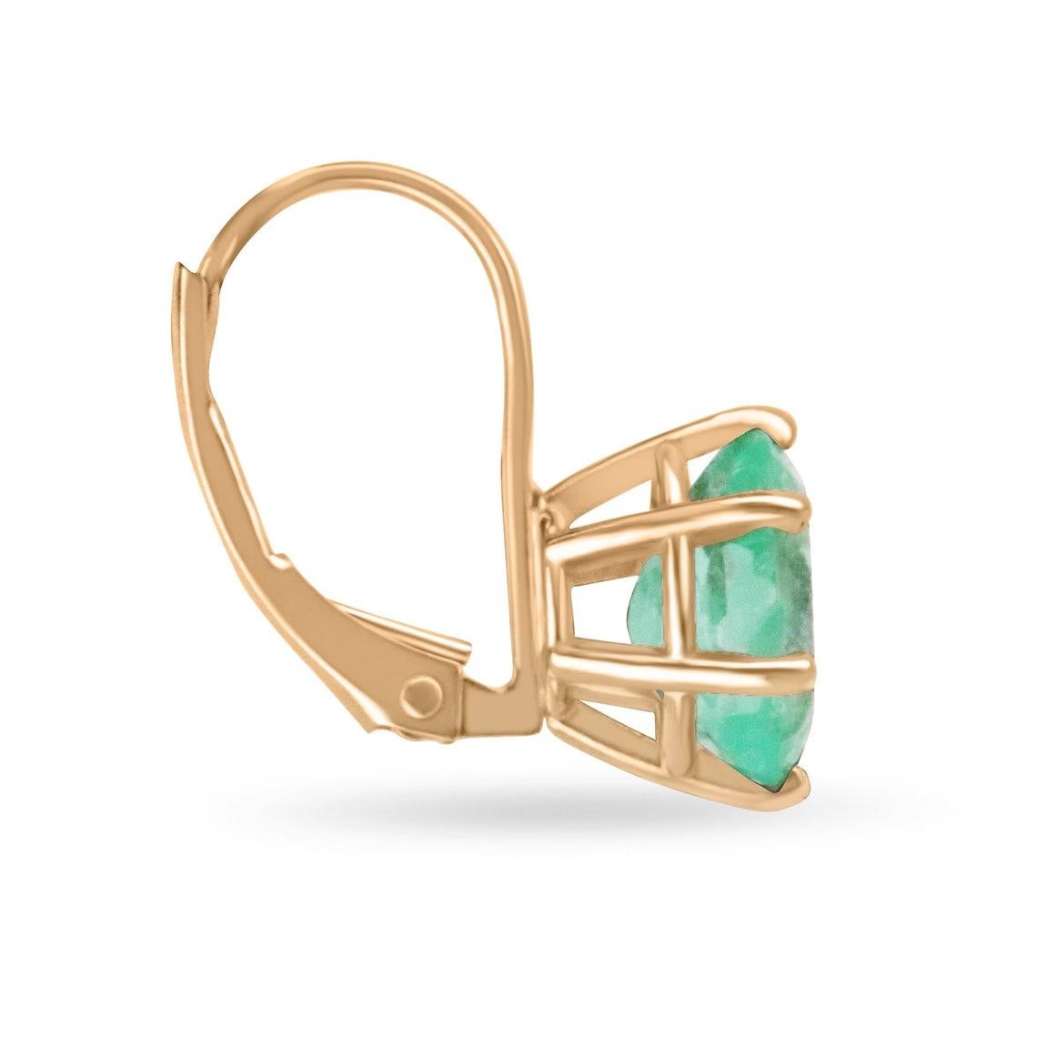 Paré de l'allure exquise de nos boucles d'oreilles à levier en forme d'émeraude de taille ovale, mettant en vedette deux gemmes captivantes provenant des paysages luxuriants de la Colombie. La teinte vert clair-moyen éthérée et la clarté