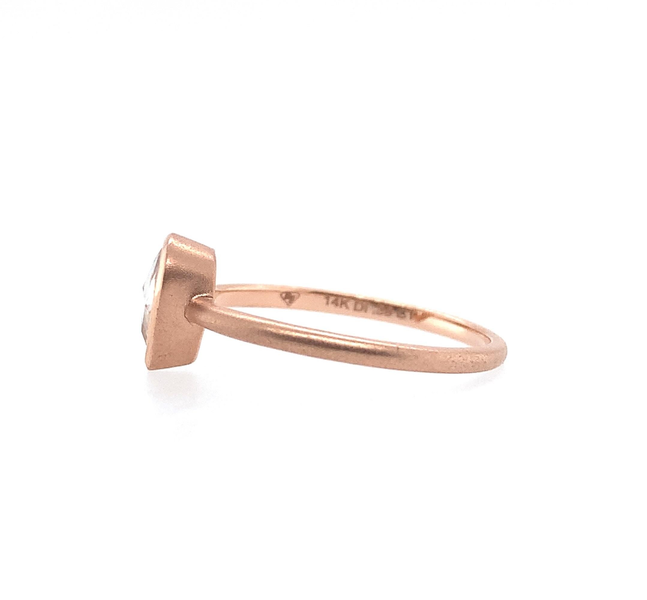 14K rose gold ring featuring a bezel set rose cut pear shape diamond. The diamond has light champagne color and measures about 6.1mm x 4.5mm. The ring fits a size 6.25 finger and weighs 1.09dwt. It is contemporary and has a brushed finish.