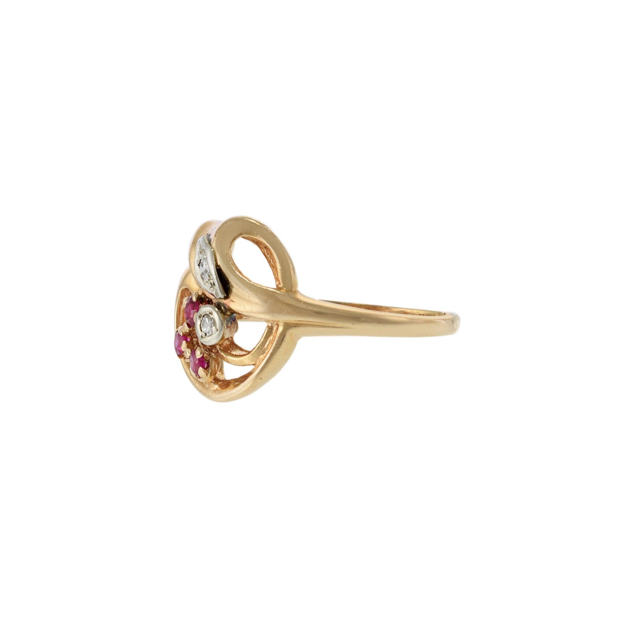A graceful ode to the Art Nouveau period, this 14K rose gold ring features an openwork floral motif with delicate scrolls and naturalistic curves. Set with round cut rubies totaling 0.10 carats and accented by 0.06 carats of round cut diamonds, the