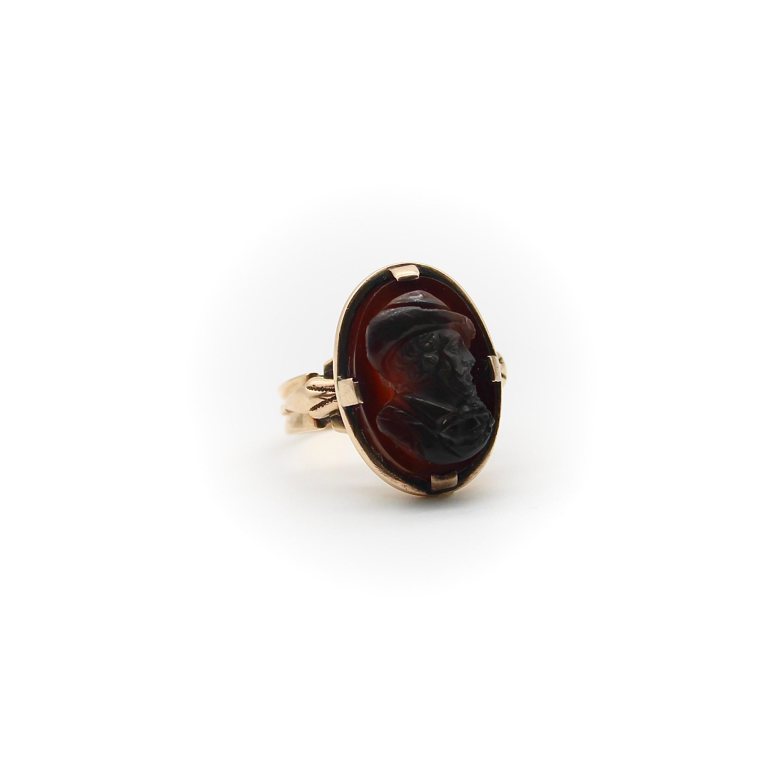 This remarkable 14k rose gold agate cameo ring features the portrait of a gentleman, depicted in profile wearing a hat and looking off into the distance. The agate is dark reddish brown, a nice compliment to the rose gold that the stone is set into.