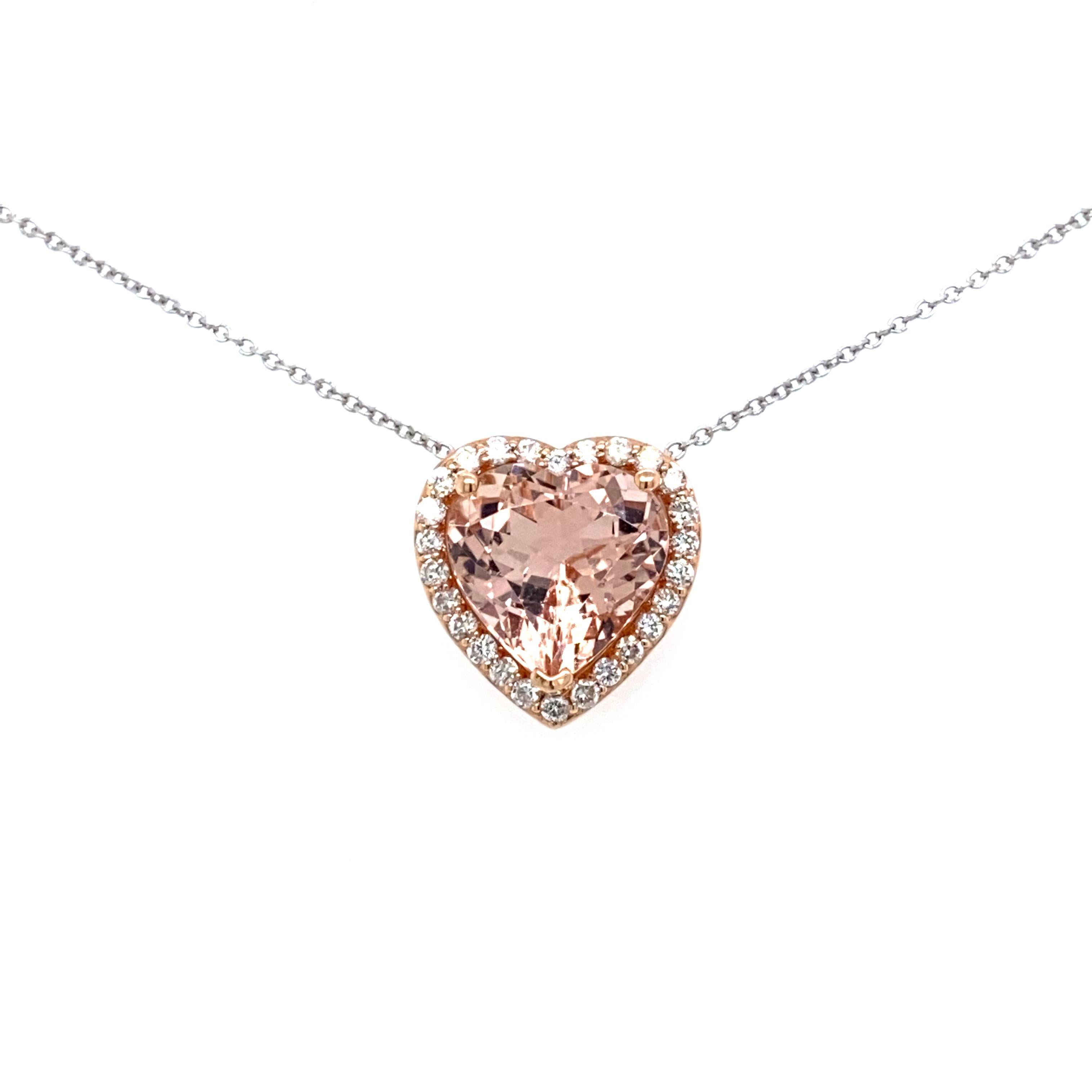 This is an exceptional natural heart-shaped morganite and diamond pendant set in solid 14K rose gold. The fancy 11MM heart morganite has an excellent peachy pink color and is surrounded by a halo of round-cut white diamonds. The pendant is stamped