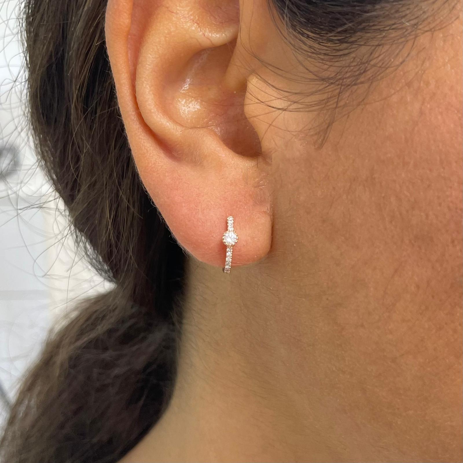 Diese schlichten und doch atemberaubenden Diamant-Huggy Hoops sind aus 14-karätigem Gold mit glitzernden weißen 0,20 Karat Diamanten gefertigt. Jeder zarte U-förmige Reif besteht aus einer einzigen Reihe weißer Diamanten mit einem einzelnen