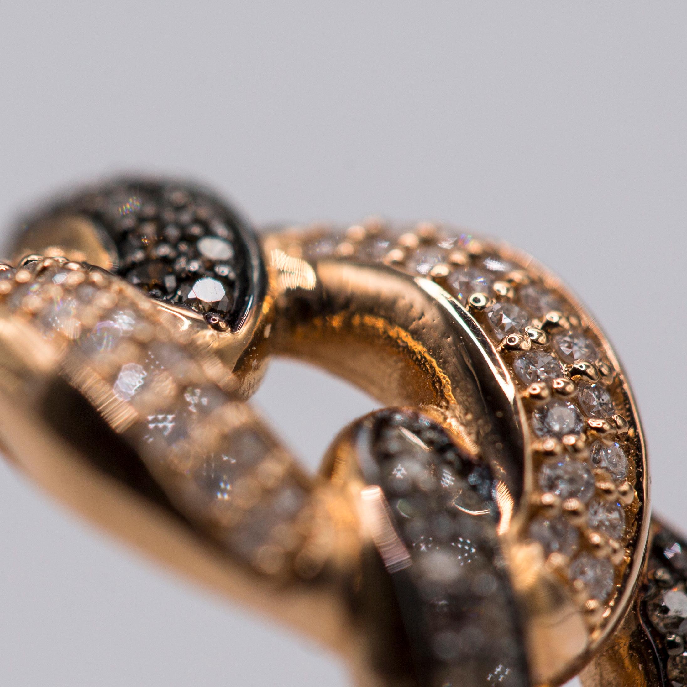 14k rose gold woven band cocktail ring with white diamonds weighing 0.18ct total and black diamonds weighing 0.34ct total weight.

