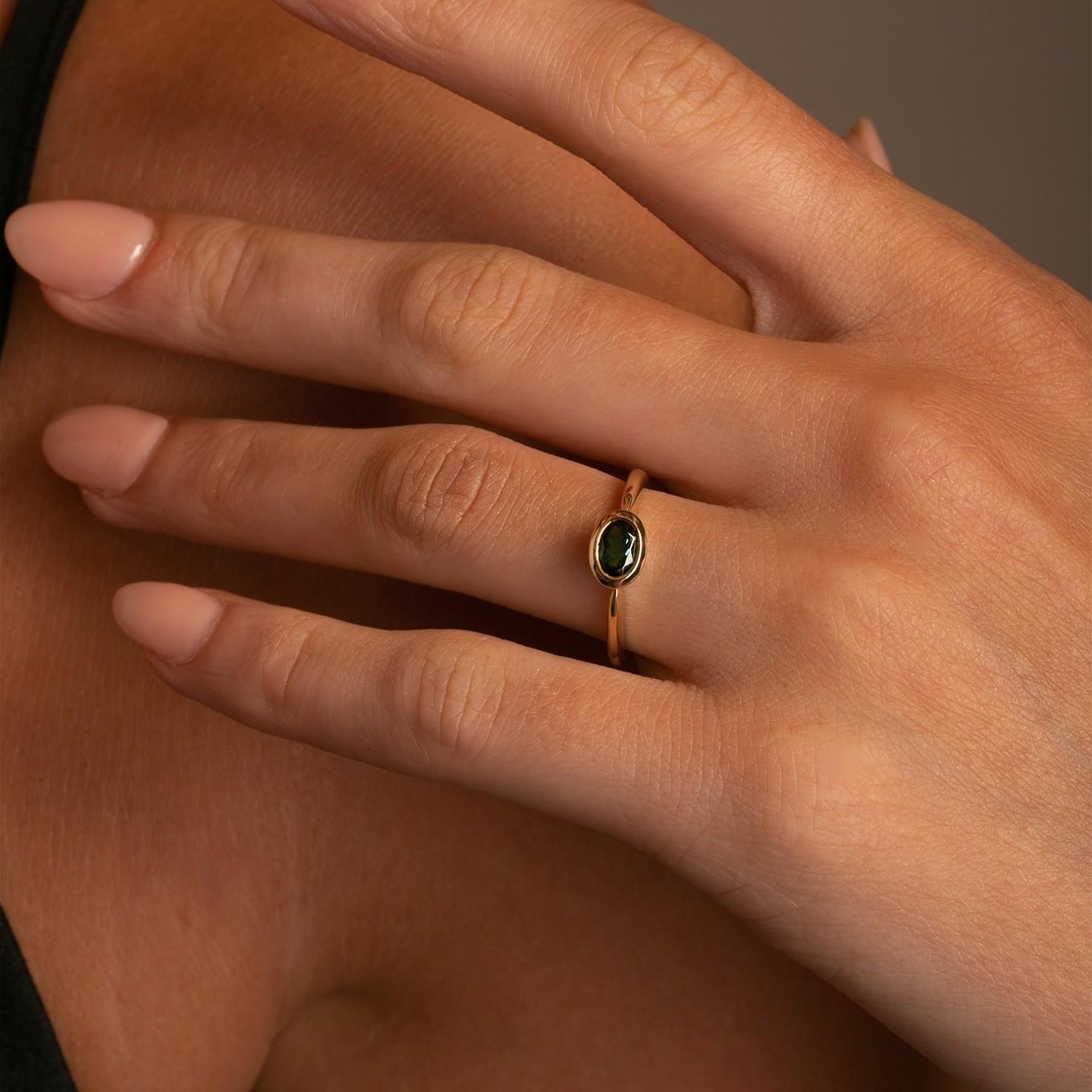 Este elegante anillo presenta una impresionante Turmalina verde ovalada, engastada en un bisel horizontal de este a oeste para lograr una estética fresca y moderna. Su elegante diseño lo hace perfecto para llevarlo solo o apilado con otros anillos,