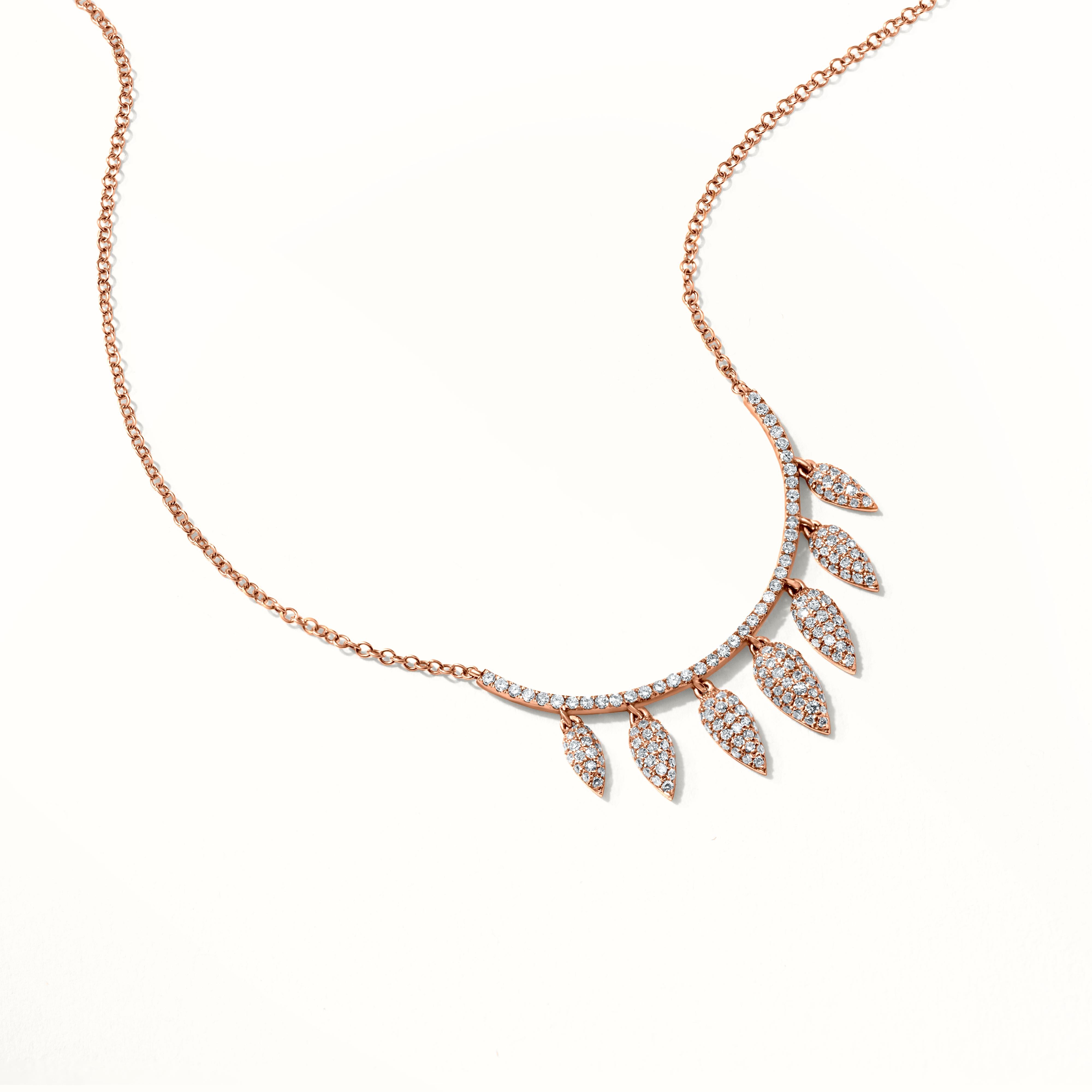 This magnificent Luxle leaf pendant necklace is made in 14K Rose Gold and sways with grace. The leaf patterns are encrusted with 0.56 carats of round single-cut diamonds that flash with brilliance. This pendant necklace is understated but beautiful,