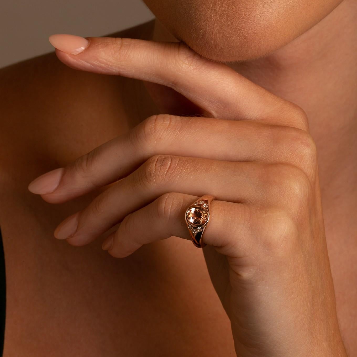 This stunning rose gold morganite and diamond ring is a modern update on the classic signet pinky ring.

Featuring a beautiful peach hued oval morganite and 6 sparkling white diamonds all bezel set in a high polished rose gold setting, this ring