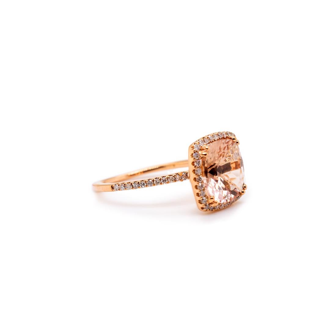 One ladies custom made polished 14K rose gold, diamond and morganite birthstone, cocktail, halo ring with a knife-edge shank. The ring is a size 4.25, is 1.38mm thick and measures approximately 1.16mm tapering to 0.92mm in width by 10.60mm in