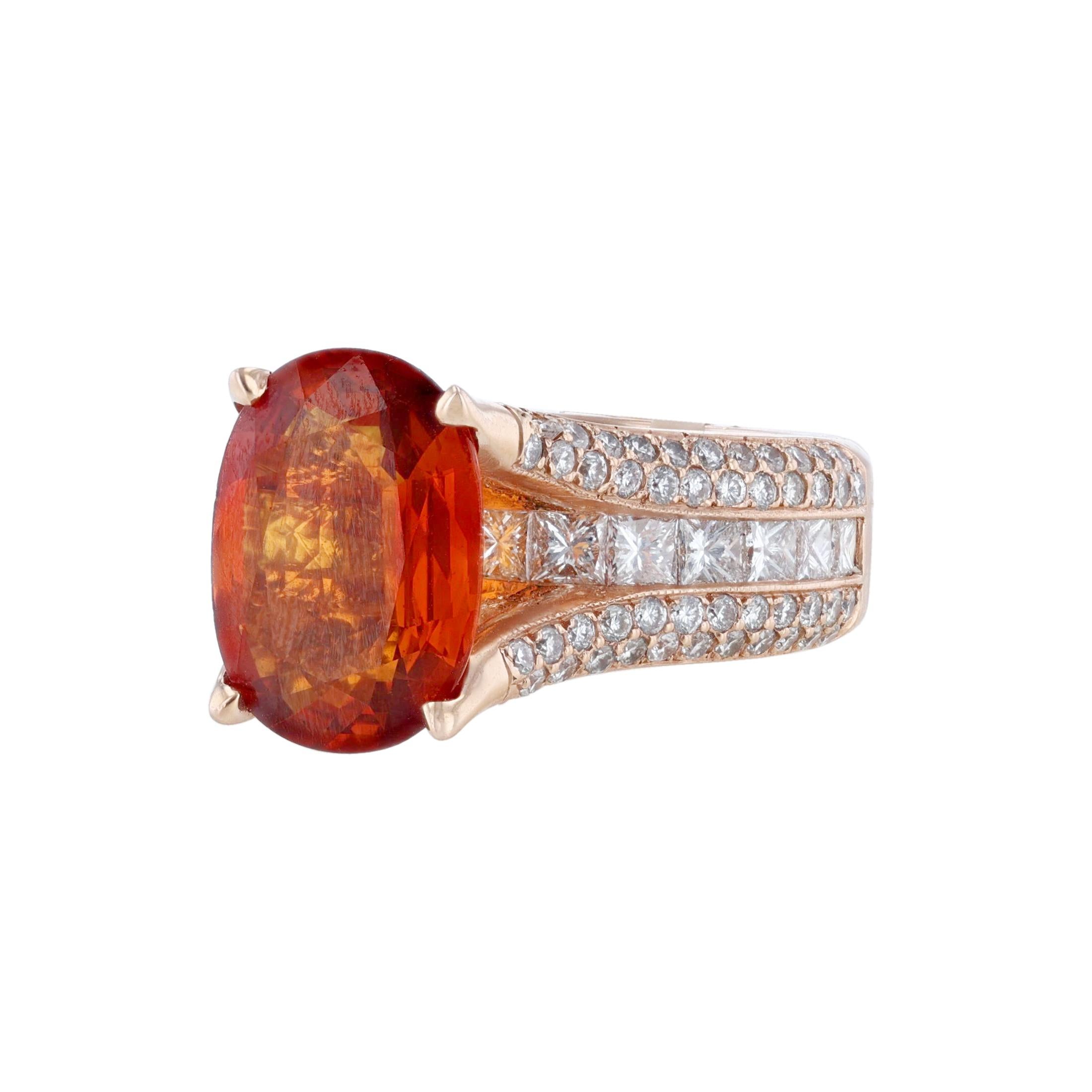 This ring is in 14K rose gold. It features 1 oval-cut orange sapphire, prong set weighing 5.03. With 4 rows of 106 round cut, prong and bezel diamonds weighing 1.14 carats. And a center row of 15 princess cut, channel set diamonds. With a color