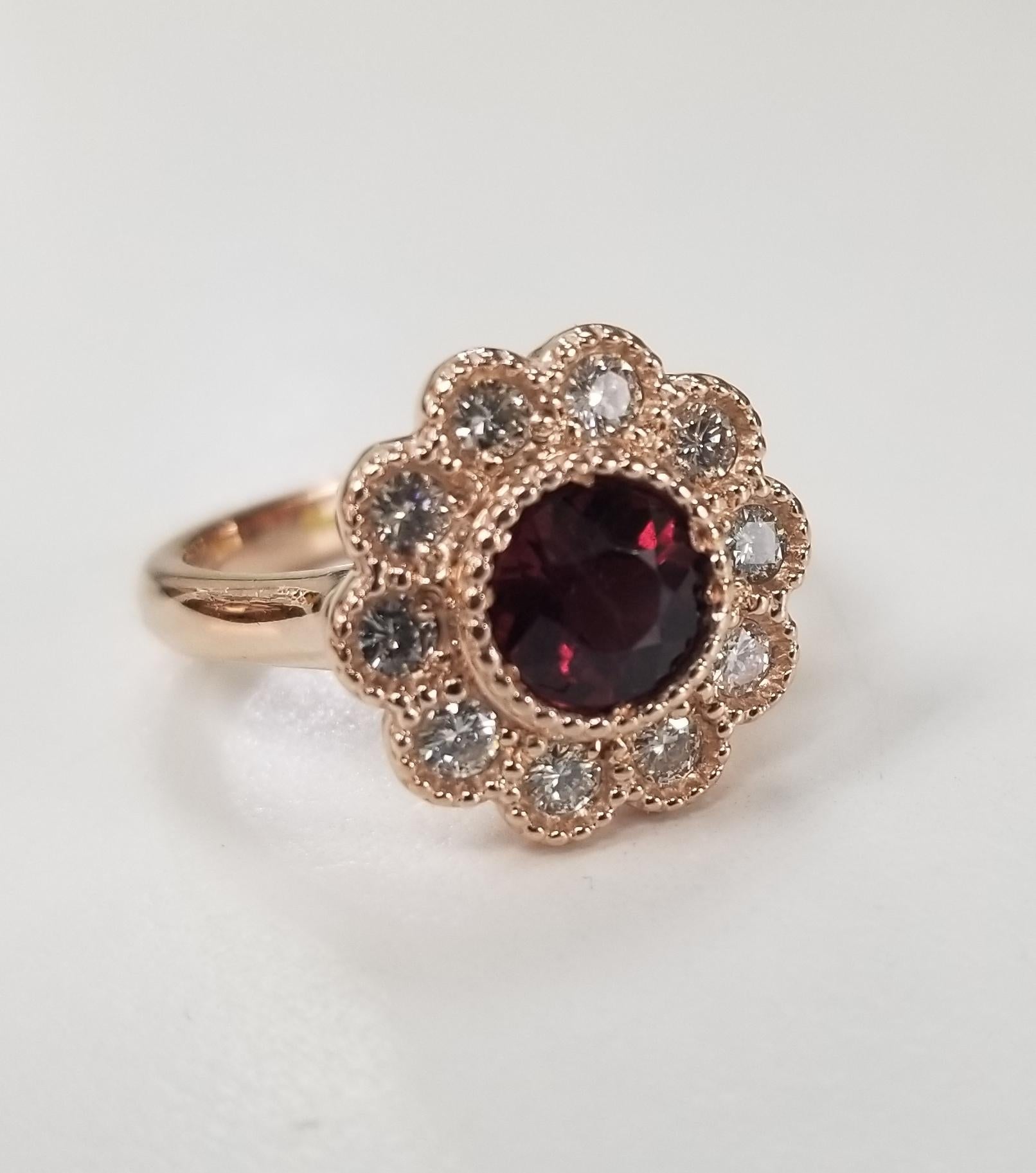 14k rose gold Rubelite Garnet and diamond halo beaded ring, containing 1 round Rubelite Garnet of gem quality weighing .88pts.  Surrounded by 10 round full cut diamonds; color 