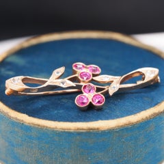 Broche de oro rosa de 14k con rubíes y diamantes
