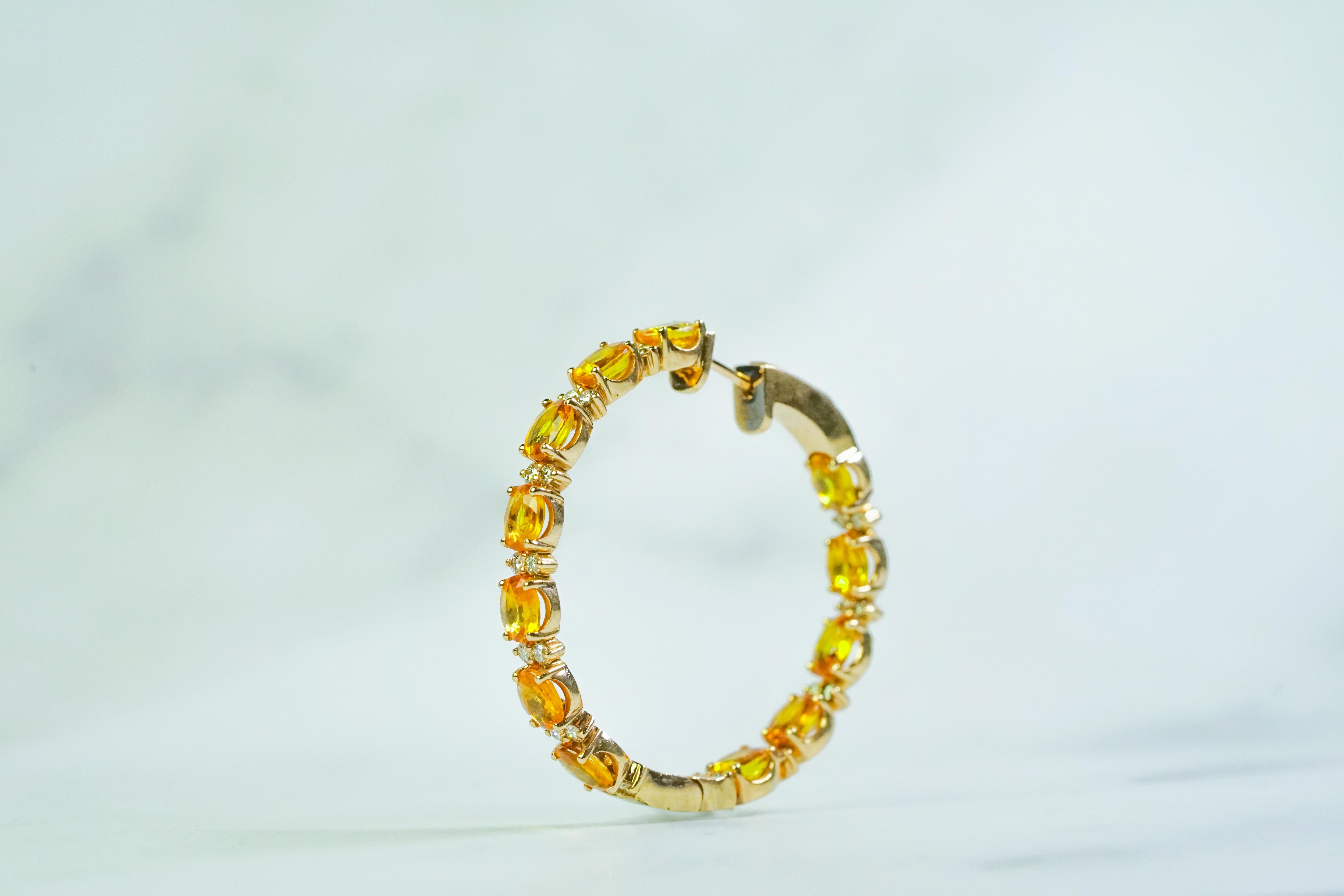 Añade un toque de lujo a tu colección de joyas con estos impresionantes pendientes de aro de oro rosa de 14 quilates.

24 Zafiros de fantasía de 10,93 ct engastados en oro rosa de 14 quilates con diamantes de 0,086 ct.

