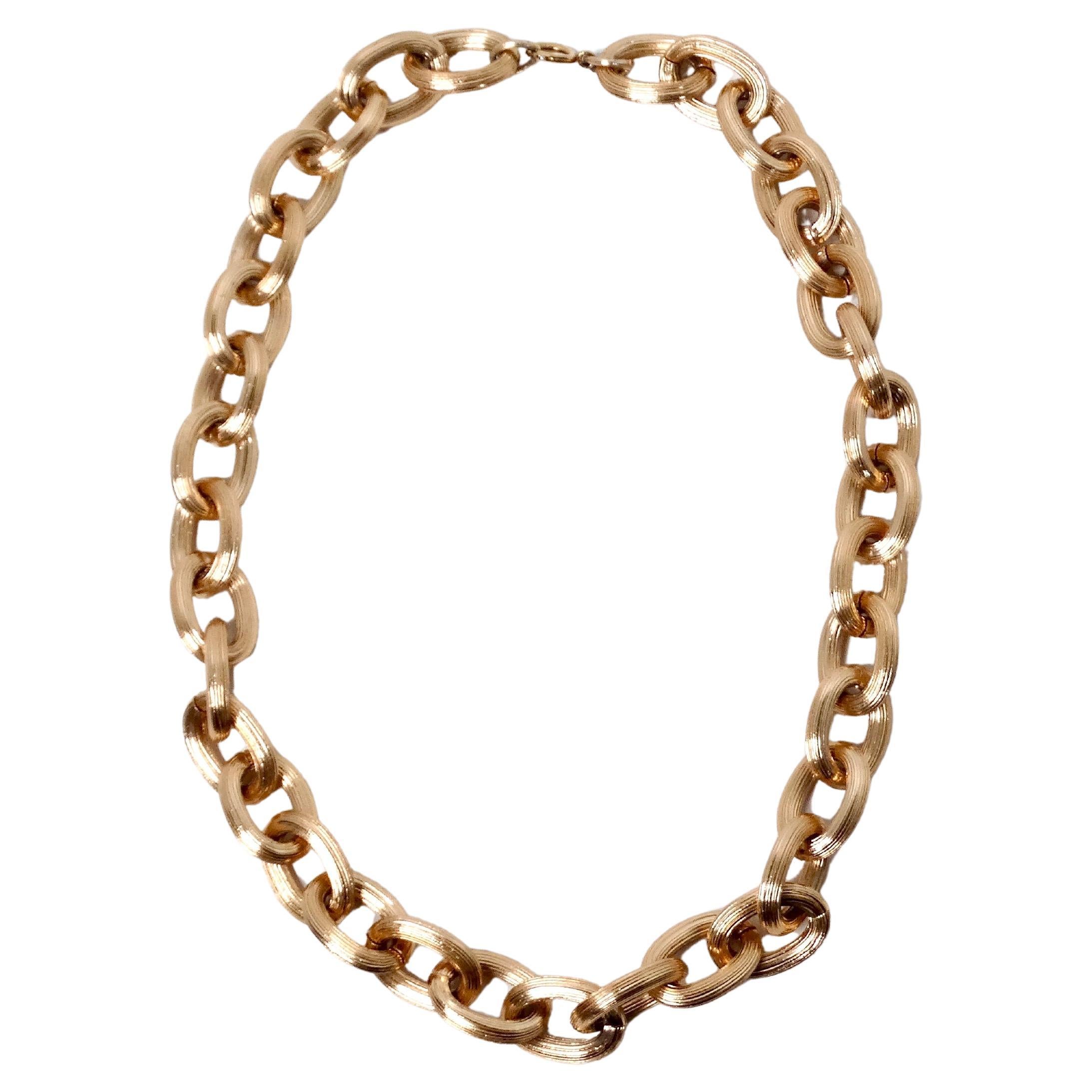 La collana Chunky Chain Link in oro rosa è un accessorio audace e contemporaneo che aggiunge un tocco di raffinatezza a qualsiasi abbigliamento. Ogni maglia unica è incisa con suggestivi motivi a strisce, che creano un affascinante gioco di luci e