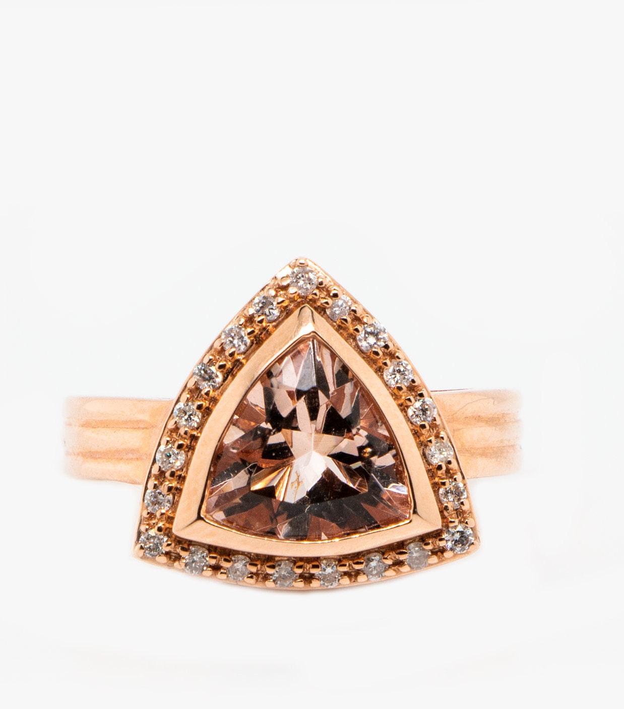 This is a gorgeous natural 2.19ct morganite and diamond vintage ring set in solid 14K rose gold. The natural 10MM trillion cut morganite has an excellent peachy pink color (AAA quality gem) and is surrounded by a halo of round cut white diamonds.
