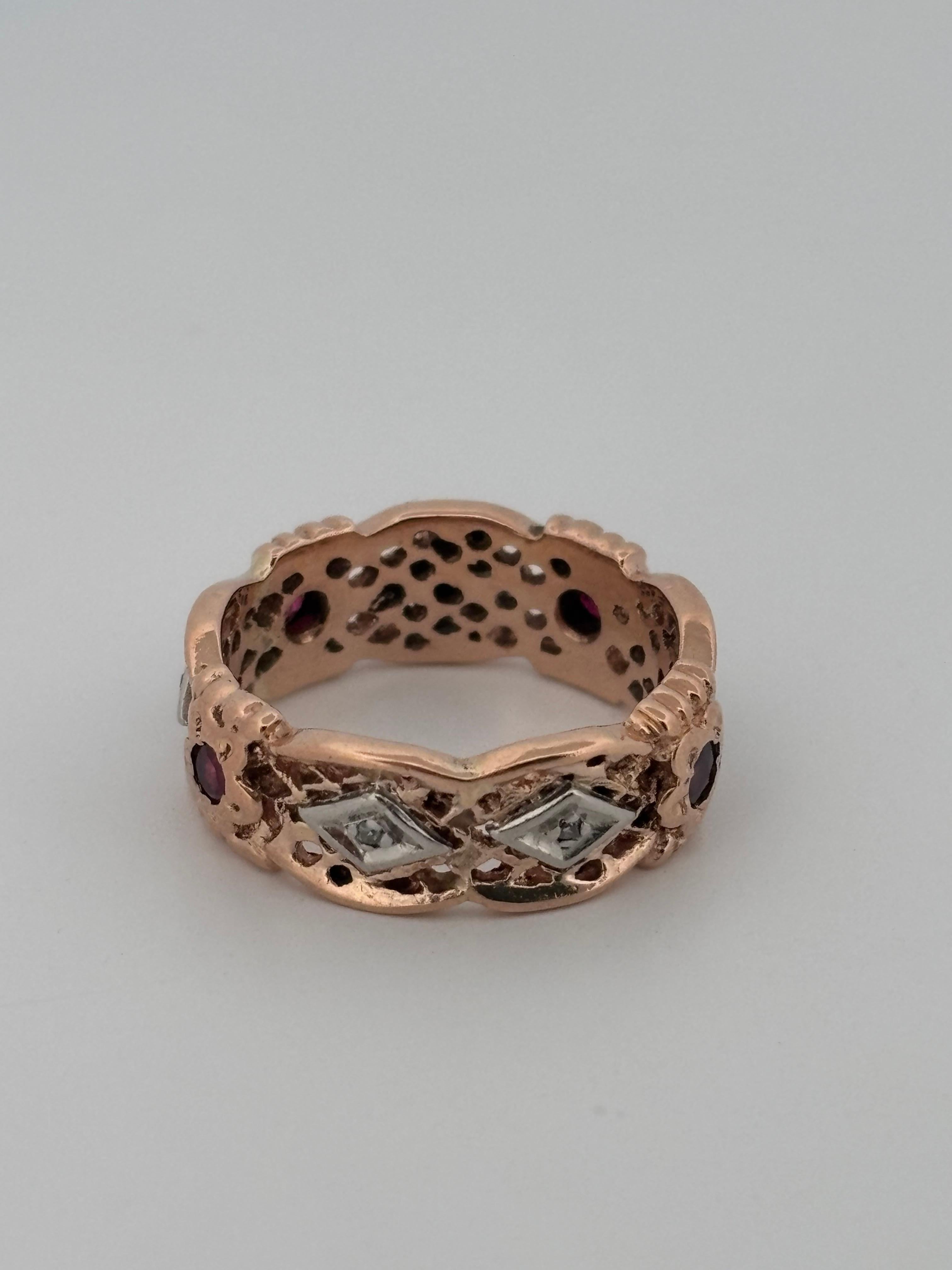 Questo squisito anello a fascia in oro rosa 14k mette in mostra un'artigianalità senza tempo e un delicato fascino vintage. Con circa 0,35 carati di rubini dalle tonalità intense, ciascuno incastonato in intricati motivi floreali, l'anello irradia