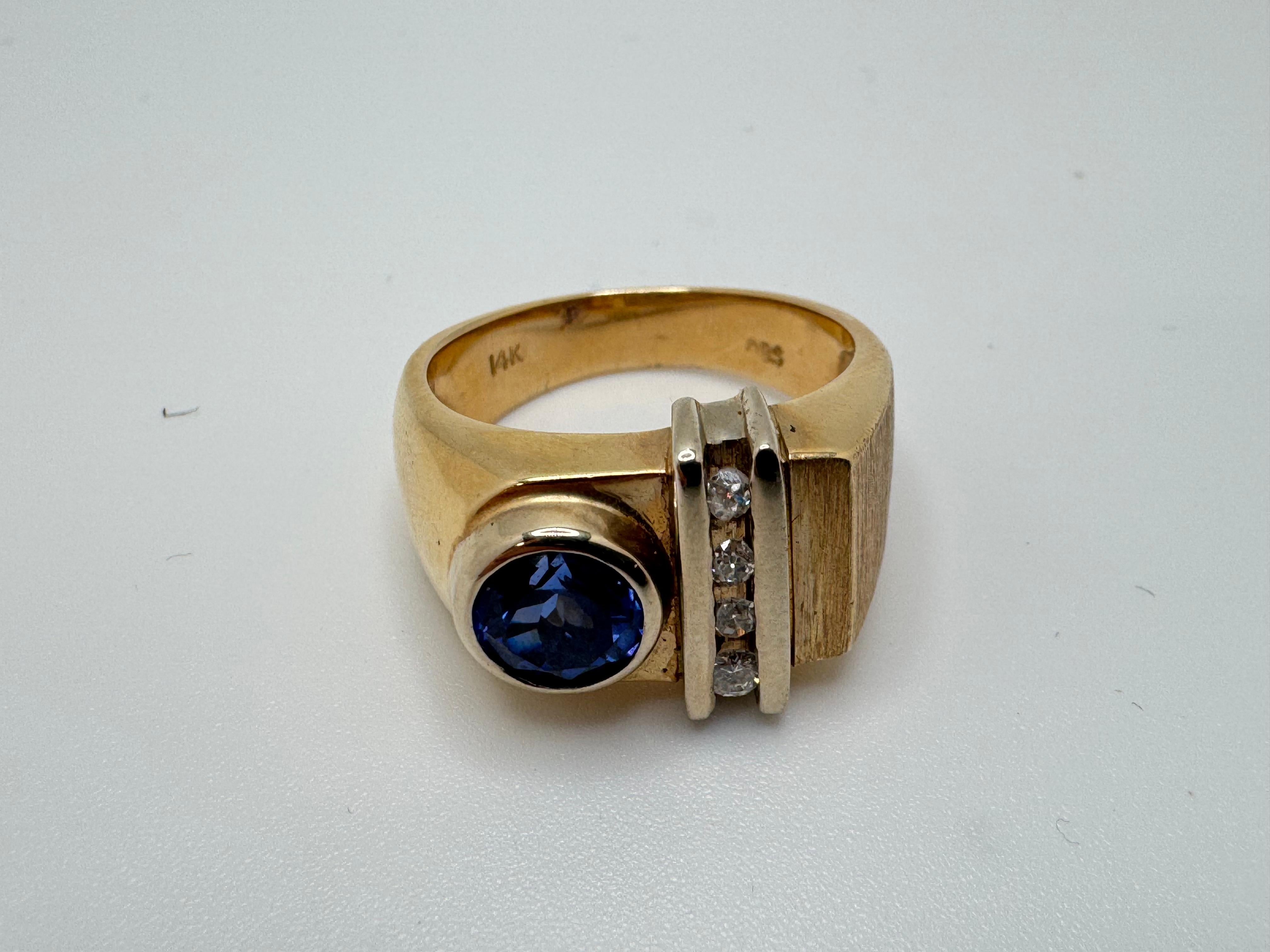 Questo audace ed elegante anello da uomo è realizzato in oro giallo 14 carati e presenta al centro un sorprendente zaffiro rotondo di 7 mm. La vibrante gemma blu è completata da quattro diamanti rotondi, incastonati per garantire sicurezza e