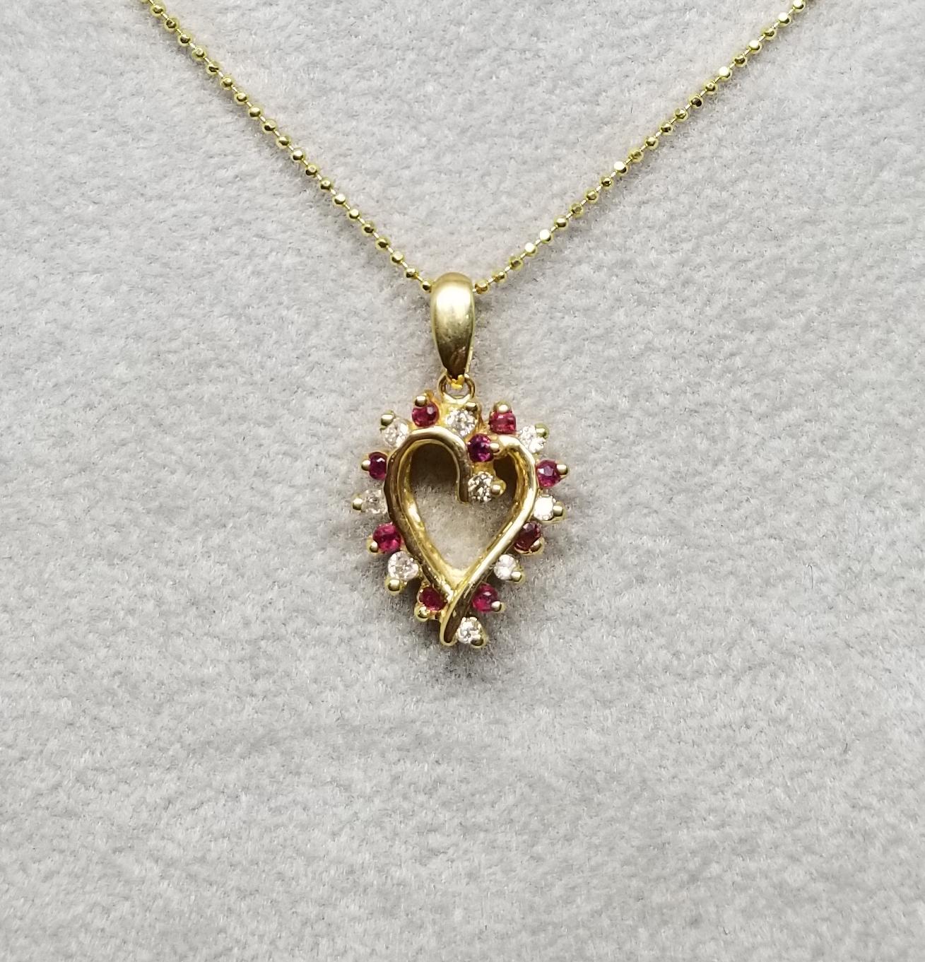 14k yellow gold ruby and diamond heart containing 9 rubies weighing .26pt. and 9 diamonds weighing .20pts. on a 16 inch chain.
