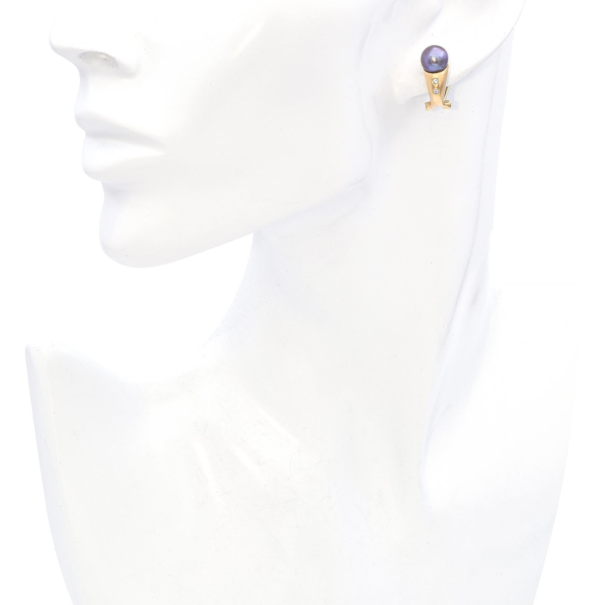 These drop earrings feature stunning Tahitian pearls set in 14k sandblast yellow gold, which adds a soft matte finish. Below each pearl, two round white diamond accent the design with subtle sparkle. The combination of the rich pearls, textured