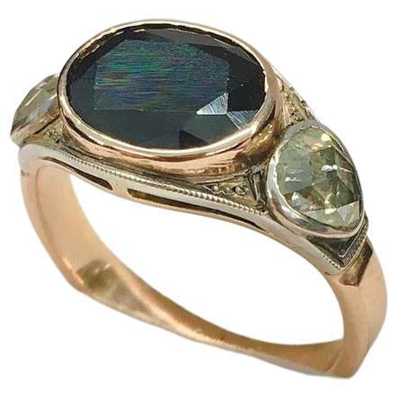14k rose gold color ring centered with natural oval cut mid night blue sapphire colour flanked with 2 rose cut diamonds estimate weight of 0.80 ct 