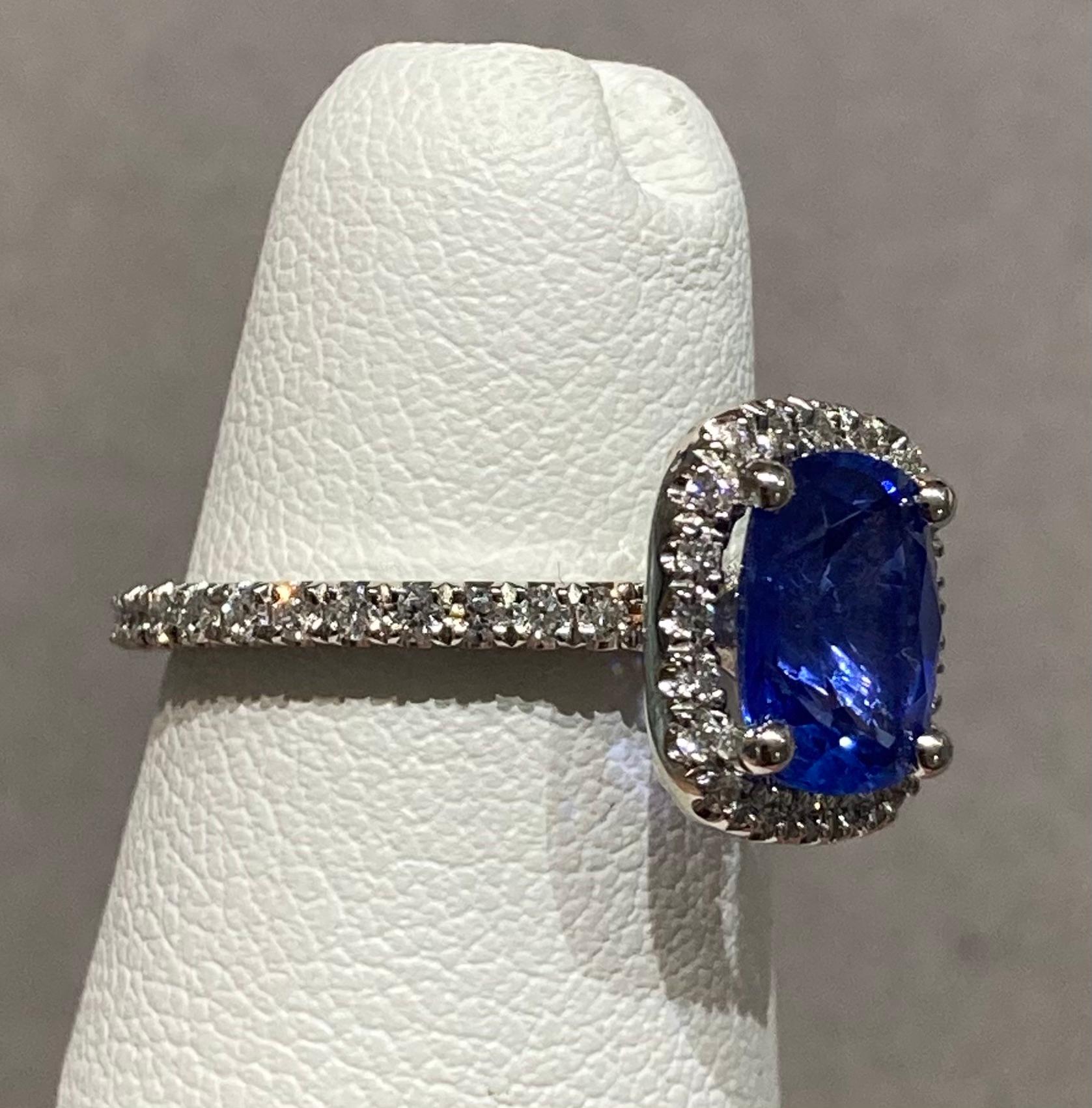 14k White gold sapphire & diamond halo ring featuring a 2.01ct sapphire set with F color/VS clarity diamonds around it and down the shank that total a weight of 0.62cts.