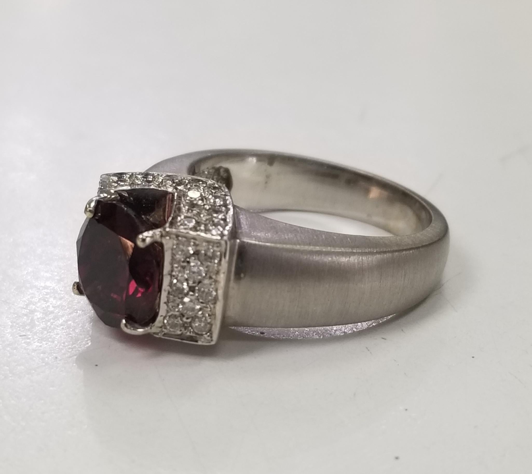 14k white gold garnet and diamond ring, containing i oval cut 