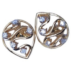 Boucles d
oreilles en or massif 14K avec diamants en forme de goutte.