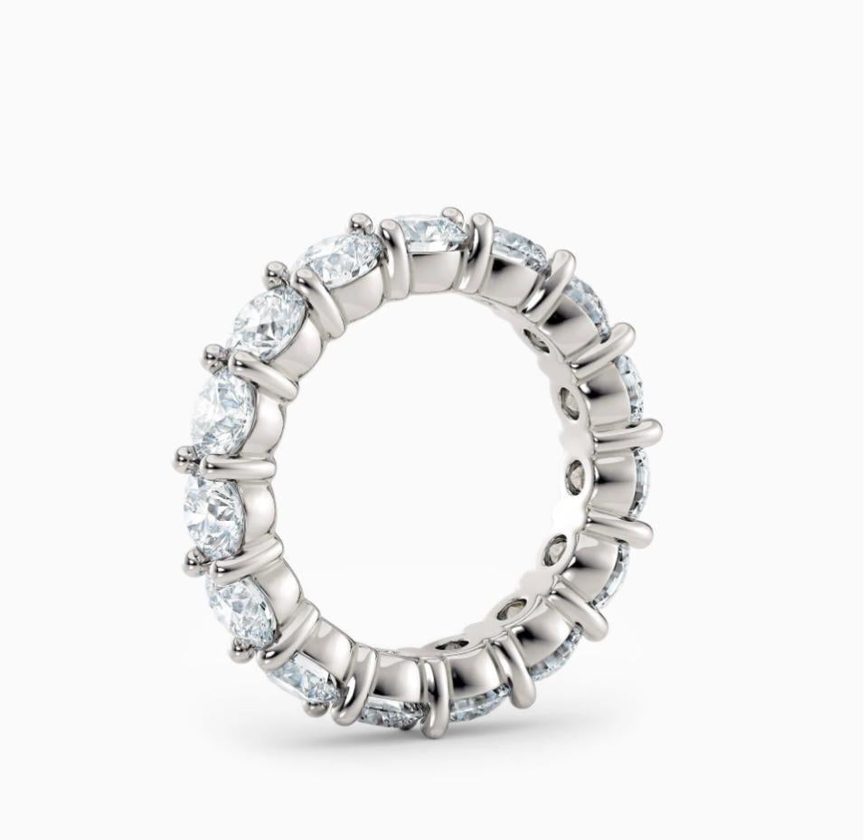 Dieser exquisite Ring zeichnet sich durch ein durchgehendes Band aus Diamanten im Rundschliff aus, von denen jeder sorgfältig in einer Zackenfassung gefasst ist, um die Brillanz und das Funkeln zu maximieren. Das aus glänzendem Weißgold gefertigte