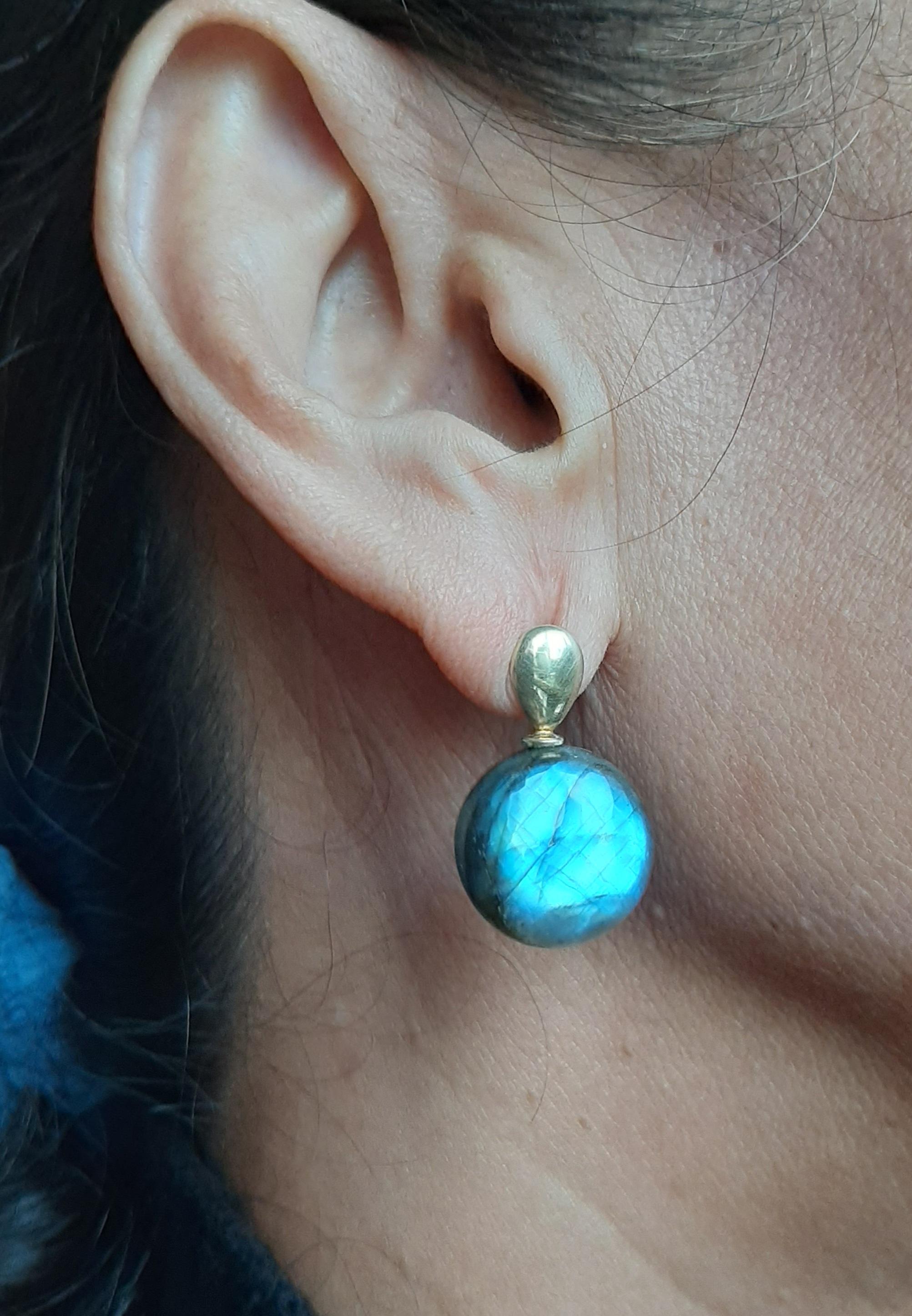 Orecchini semplici ed eleganti con un paio di punte piatte a forma di pera in oro giallo 14 Kt. e nella parte inferiore 2 labradoriti tonde a forma di tondo.  17 mm di diametro
Nel 1978 il nostro laboratorio ha iniziato a realizzare gioielli in