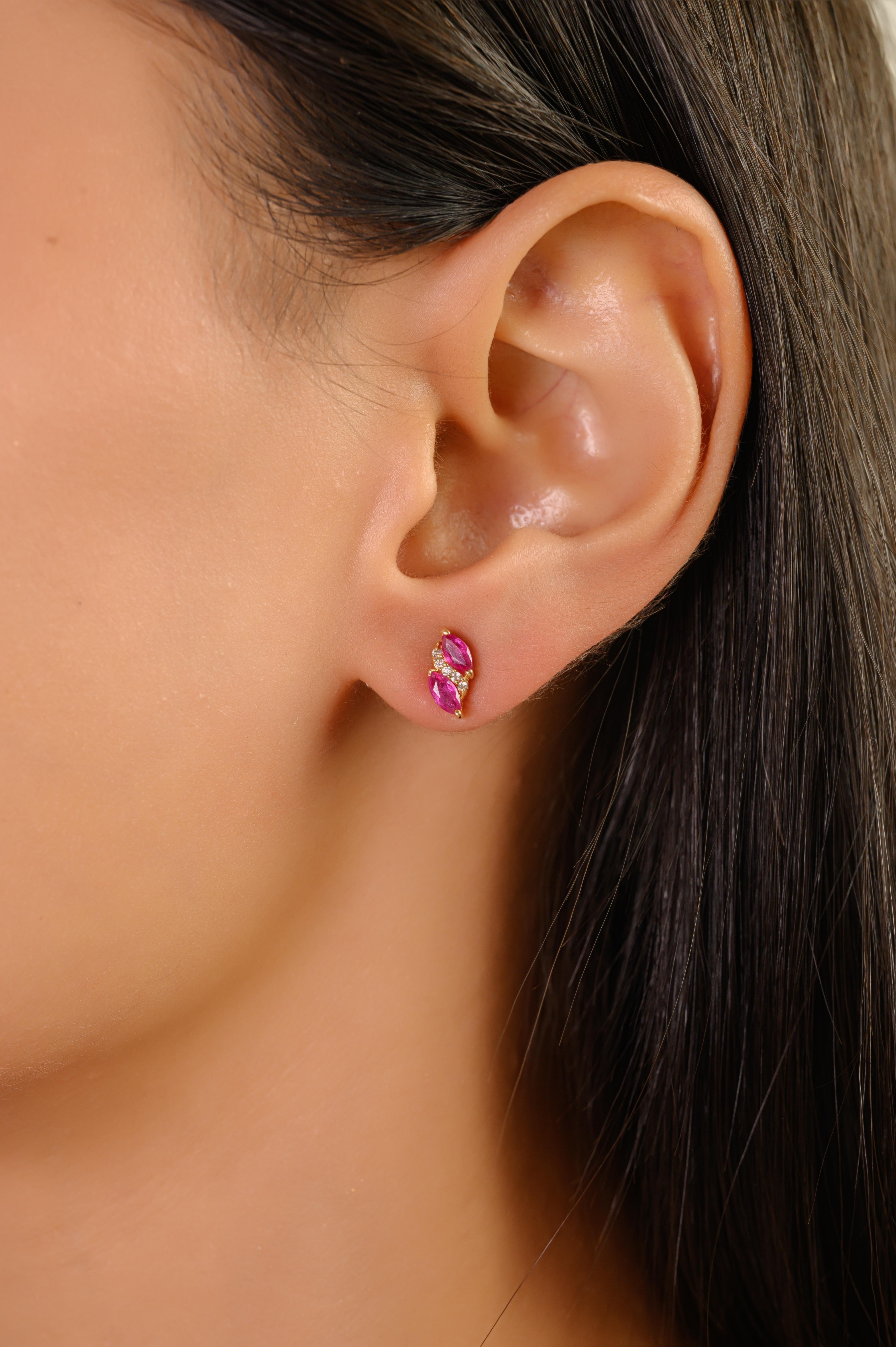 Ces boucles d'oreilles contemporaines présentent 4 rubis naturels taille marquise totalisant 0,74 carats, chacun mesurant environ 4x2,3 mm, solidement sertis dans des montures à griffes en or jaune 14 carats. Les rubis sont rehaussés d'une délicate