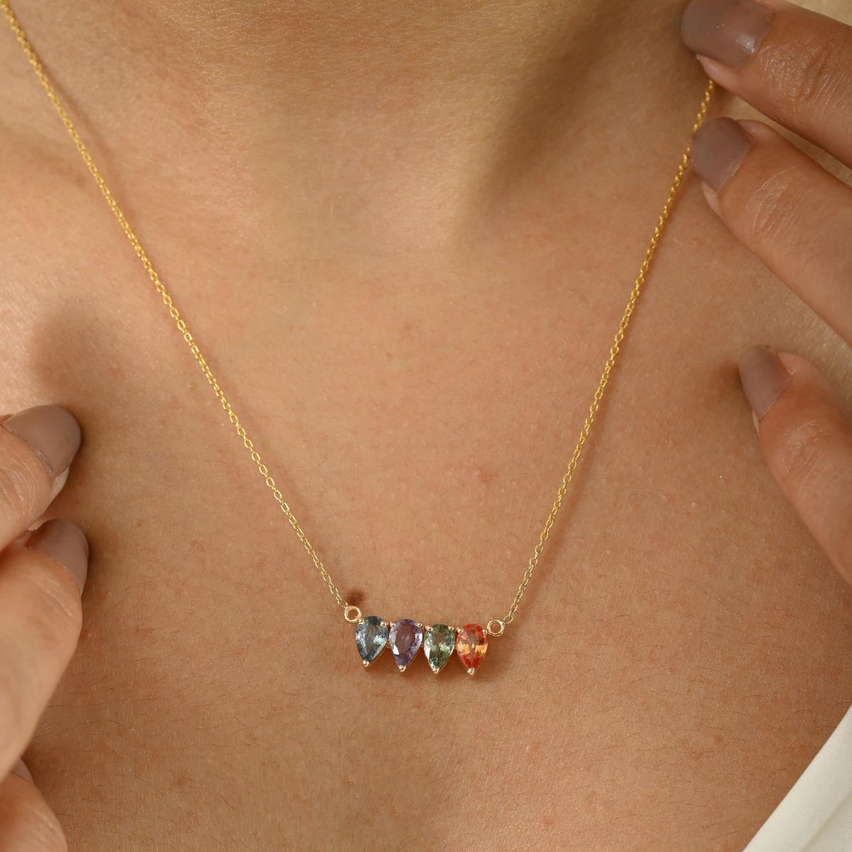 Ajoutez une touche vibrante d'élégance à votre collection de bijoux avec ce collier exquis à plusieurs saphirs. Réalisé en or jaune 14k, le collier présente quatre saphirs en forme de poire magnifiquement facettés dans un spectre de couleurs