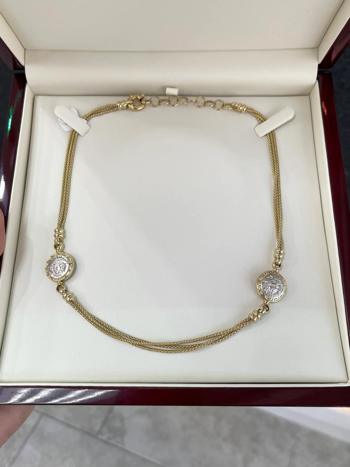 Werfen Sie einen Blick auf diese atemberaubende Medusa-Halskette aus massivem Gold. Dieses Stück ist wirklich einzigartig und ein Unikat. Gefertigt aus glänzendem 14-karätigem Gelbgold, fallen drei einzelne Kästchenketten mit einem Durchmesser von