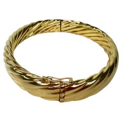 Bangle rotondo con coperchio a tortiglione in oro giallo massiccio 14K