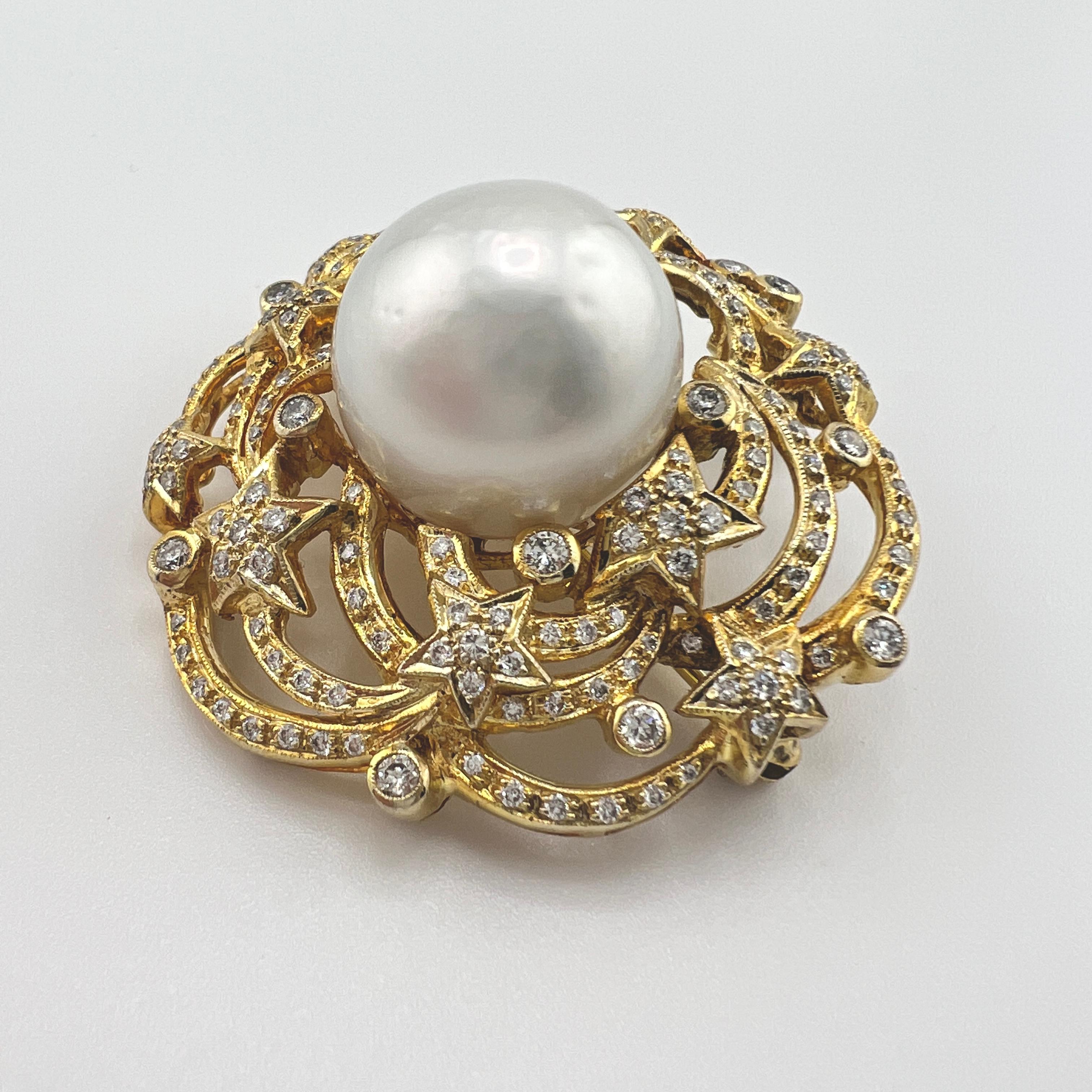 A 14k yellow gold pendant and brooch displaying a sea of diamond-encrusted stars centered by a wonderfully round 16mm South Seas pearl with incredible luster and mild blemishes. 
