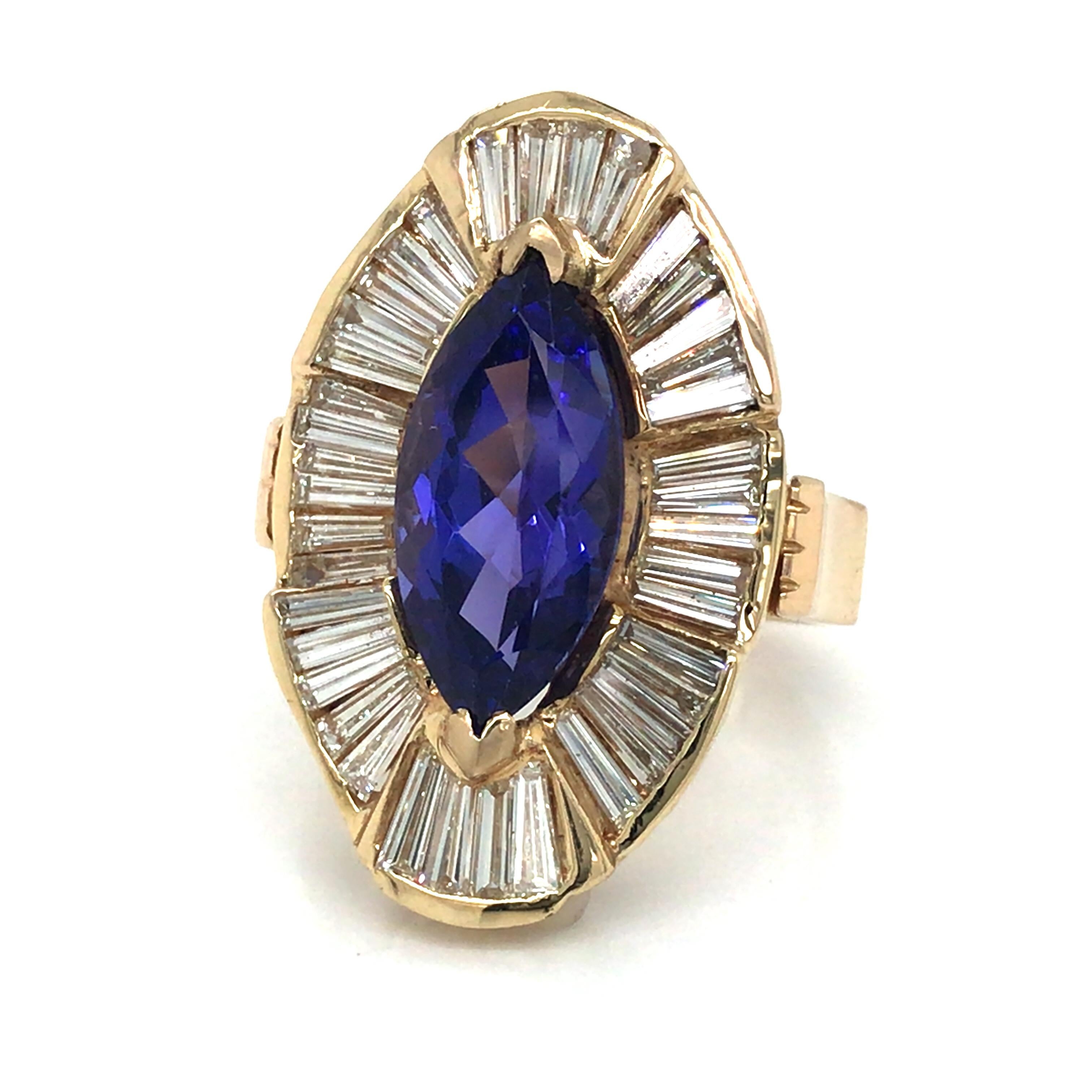 Tanzanite and Diamond Ring in 14K Yellow Gold.  Baguette Diamonds weighing 4.03 carat total weight, G-I in color and VS-SI in clarity are expertly set around the 6.20 Carat Tanzanite Center.  The Ring measures 1 1/4 inch in length and 5/8 inch in