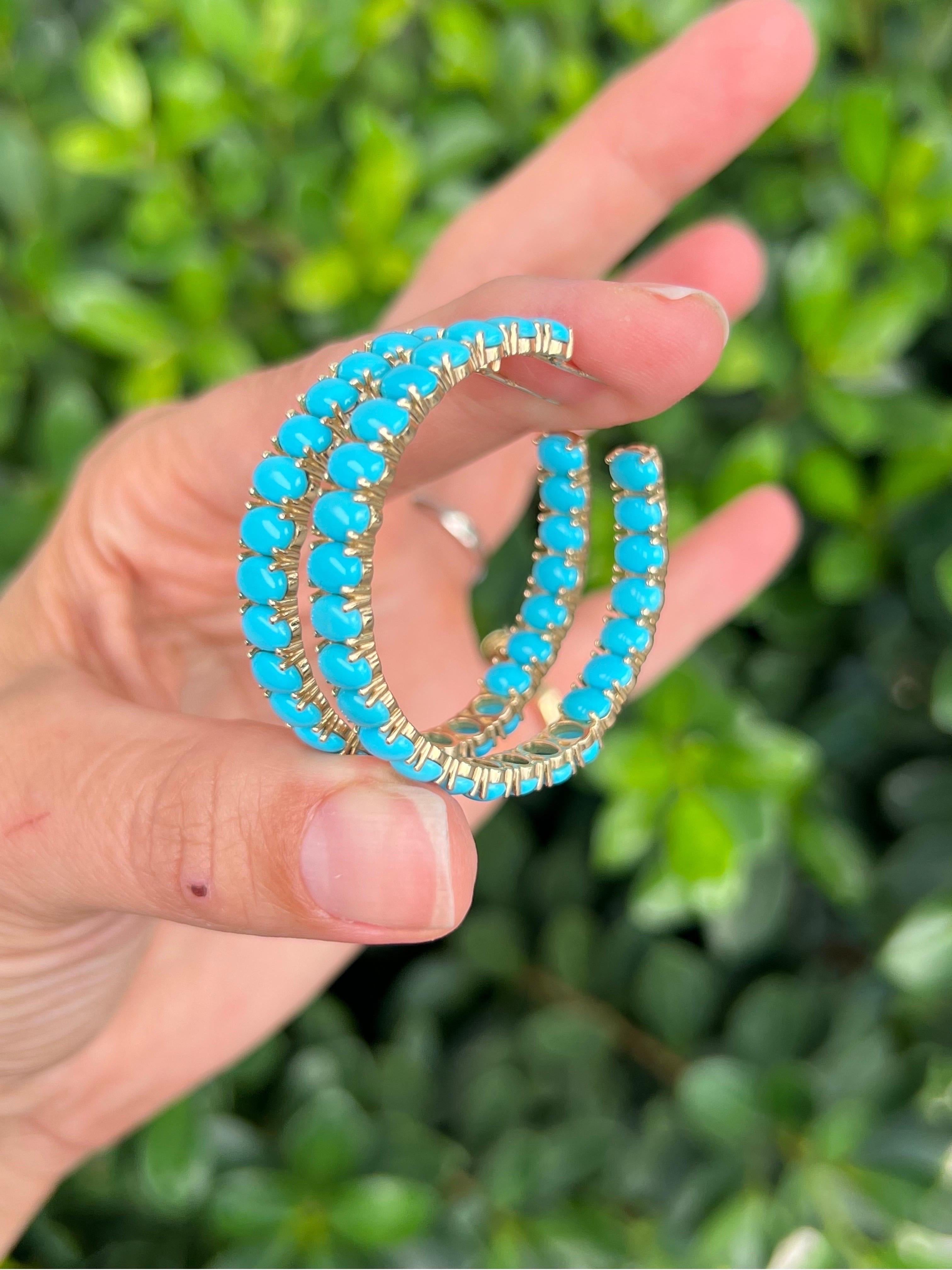 14k yellow gold turquoise hoop earrings. 40 mm in diameter and 6 mm width with an inside out design and a push back closure. 

Features
14K yellow gold
oval cabochon turquoise
post earring with push back
40mm diameter, 6mm width