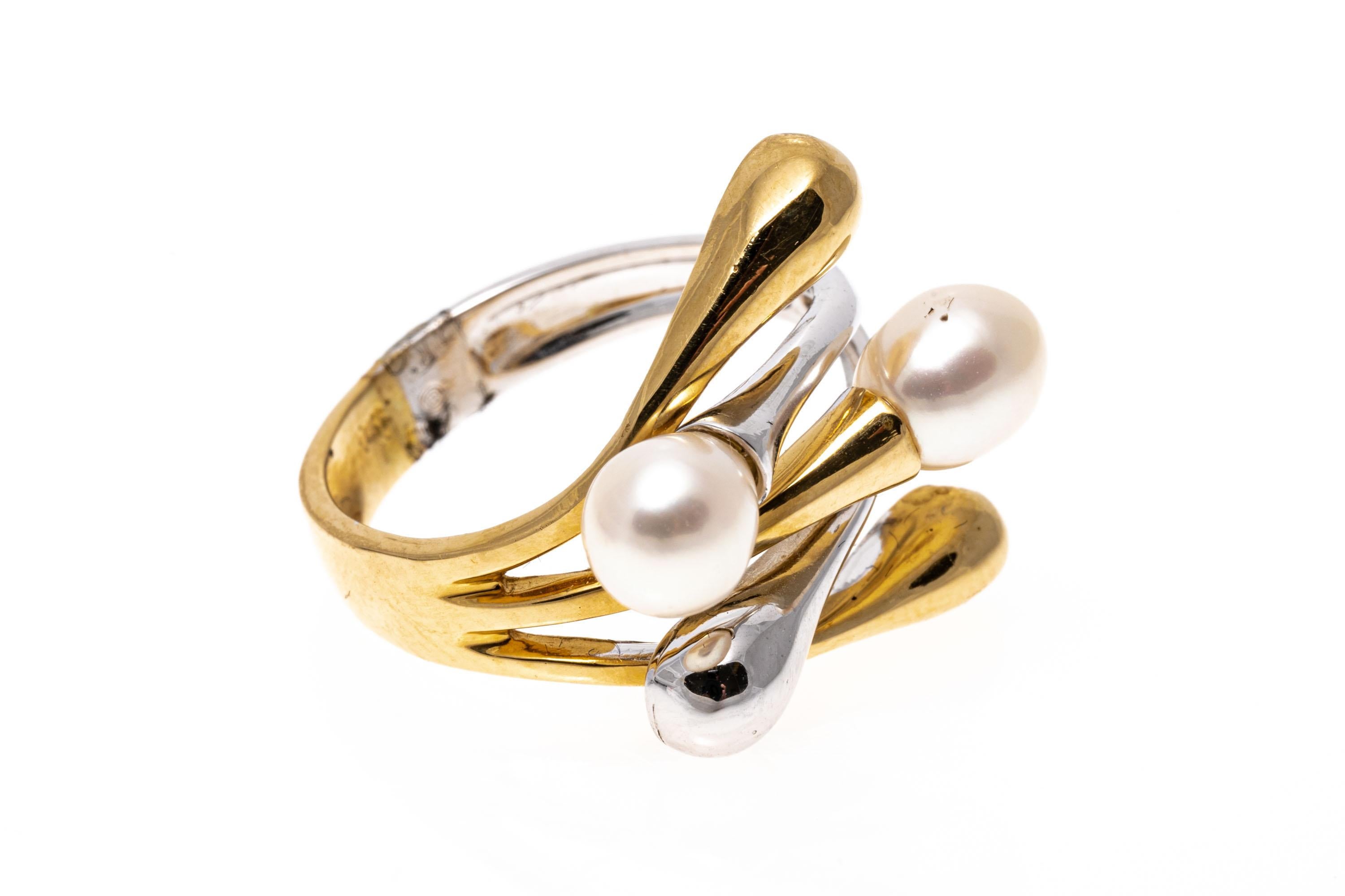 14K two-tone ring. This unique ring features a contemporary intertwined high polished yellow and white branching design spanning out from the center, decorated with alternating cultured freshwater pearls on the ends.
Marks: 14K
Dimensions: 3/4