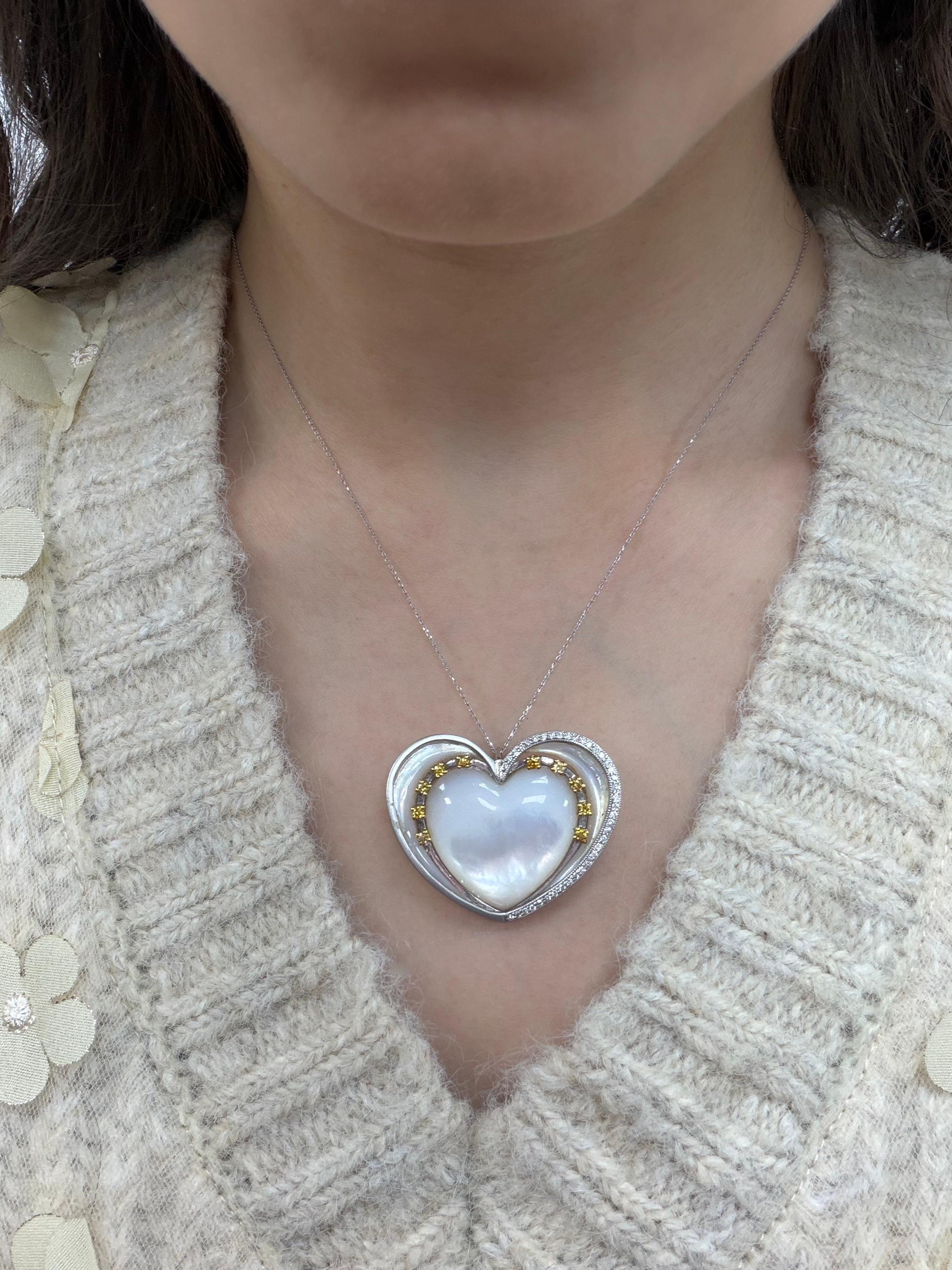 Questo splendido ciondolo a forma di cuore presenta una madreperla di 26,45 carati incorniciata da rebbi in oro bianco e giallo 14K. Accentuato da 0,47 carati di diamanti tondi brillanti e 0,28 carati di vibranti zaffiri gialli, il design bilancia