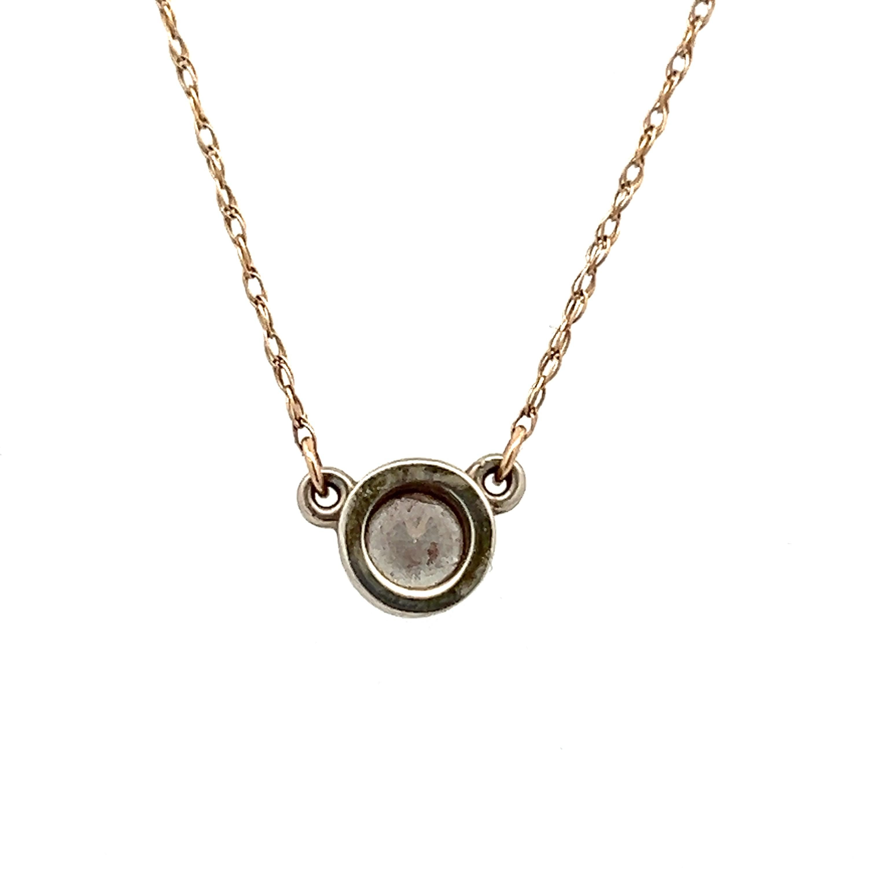 This contemporary 19.5-inch wheat chain necklace is crafted from 14 karat yellow gold and is paired with a 0.26-inch 14 karat white gold and diamond pendant. The pendant features a bezel-set round brilliant cut diamond, approximately 0.33 carats,